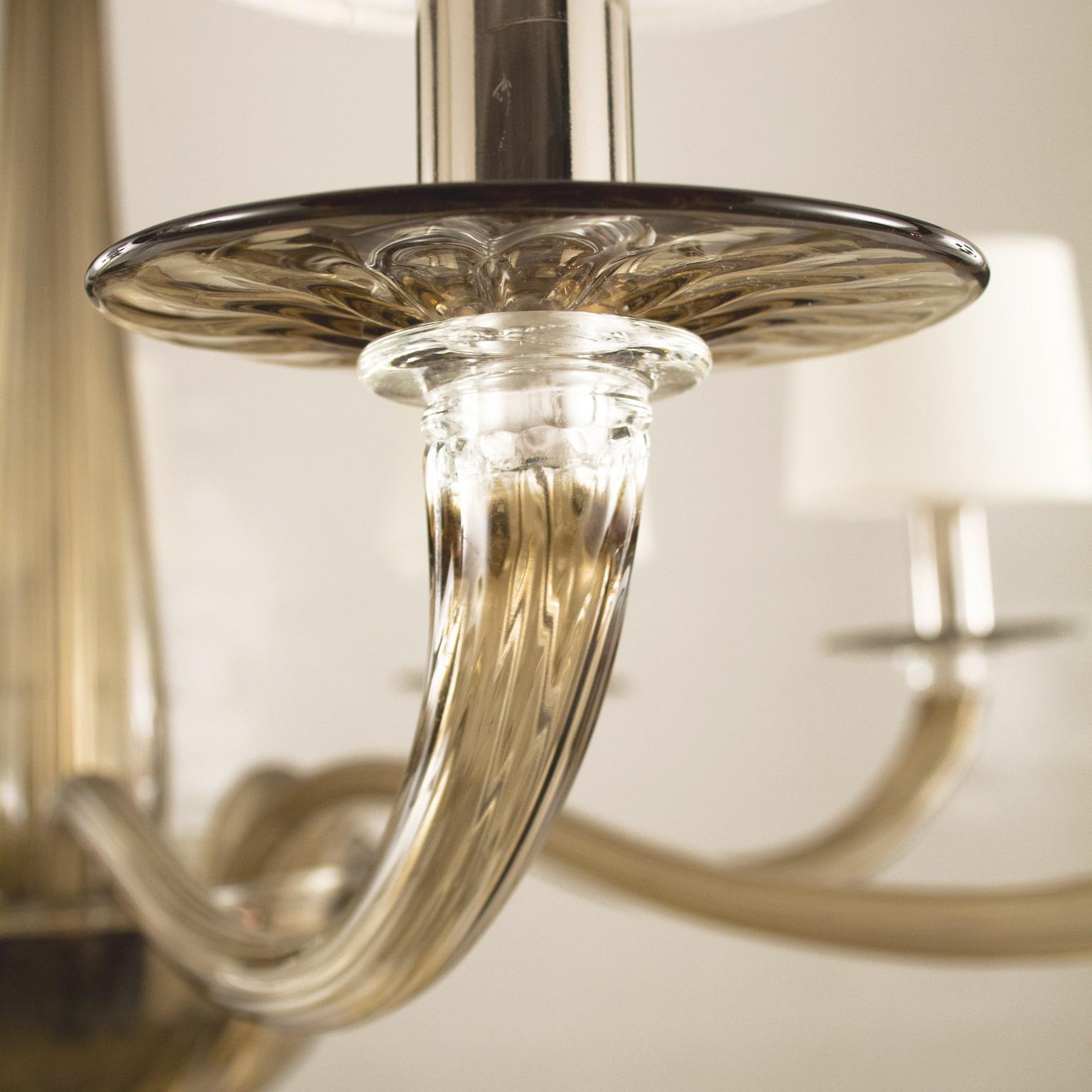 Lampadario Serenade 8 luci in vetro di Murano noce, paralumi in cotone bianco morbido fatti a mano di Multiforme
La collezione Serenade si ispira a un design contemporaneo e internazionale, semplice ma non banale, ed è composta da elementi studiati