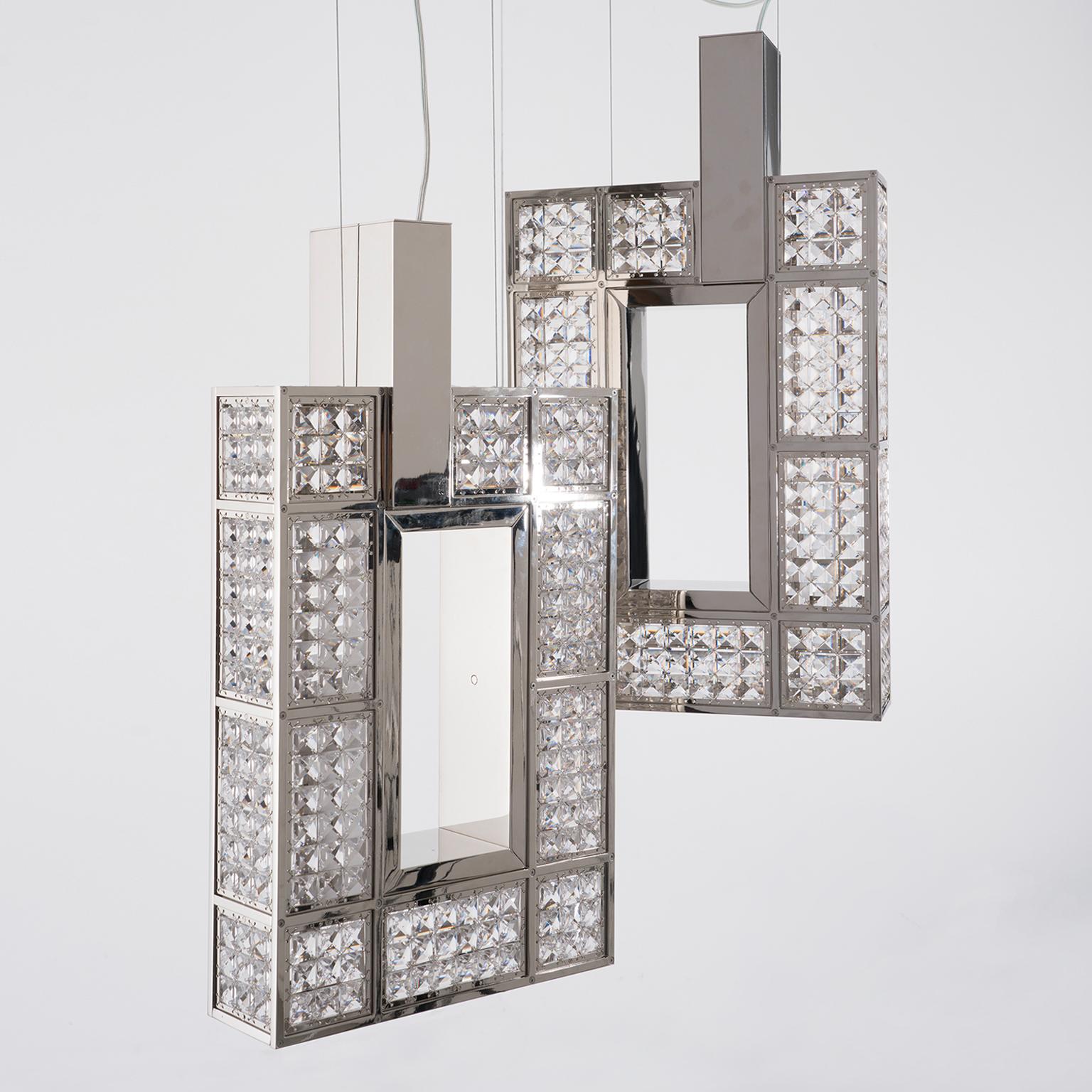 A sophisticated bright jewel, an unusual and unique interpretation of a chandelier.
Simple lines and squared geometries covered by a crystal net. The result is a truly glittering piece.
