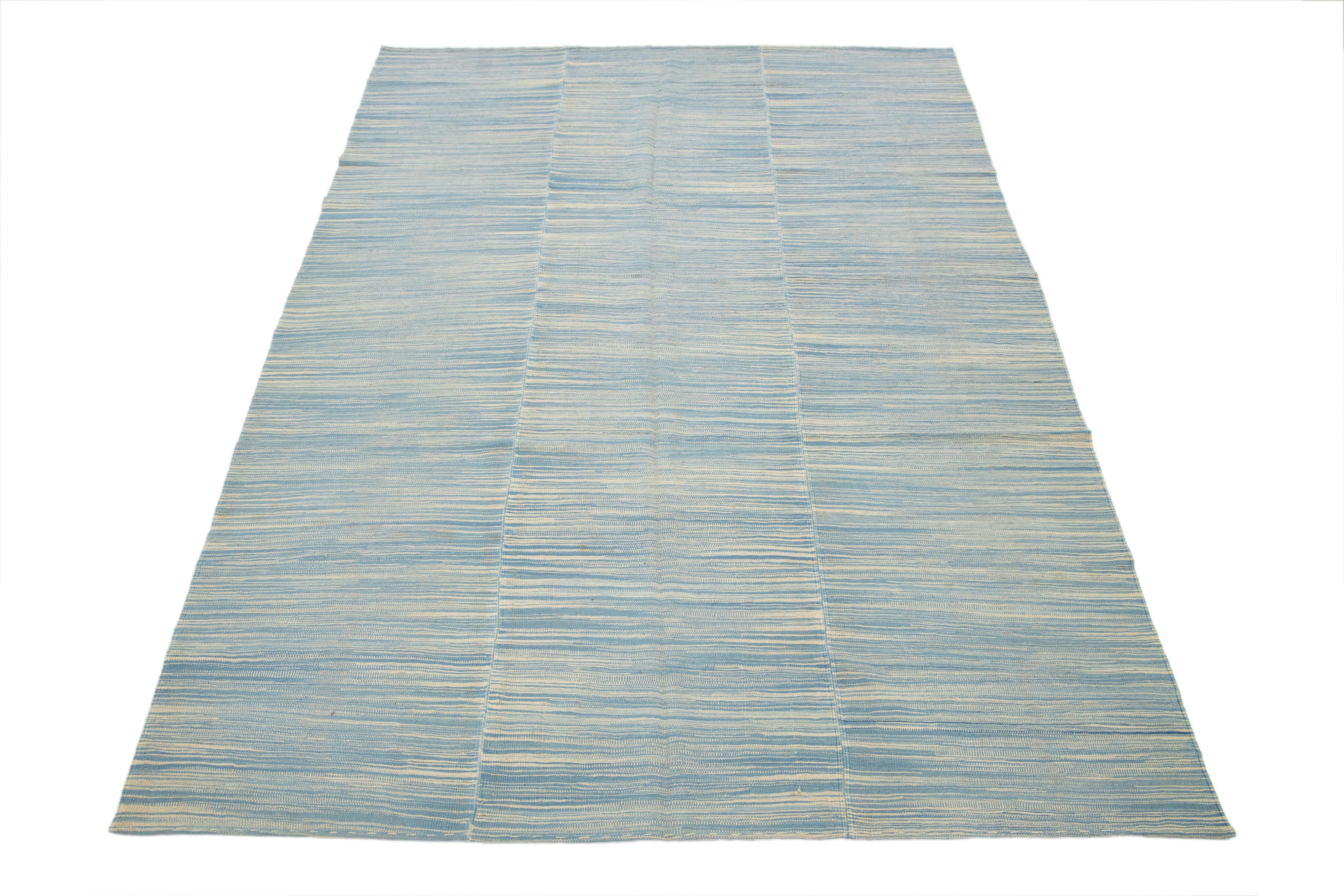 Zeitgenössischer türkischer Kelim des 21. Jahrhunderts, ein handgeknüpfter Wollteppich mit einem abstrakten Muster in Hellblau und Beige.

Dieser Teppich misst 6'8