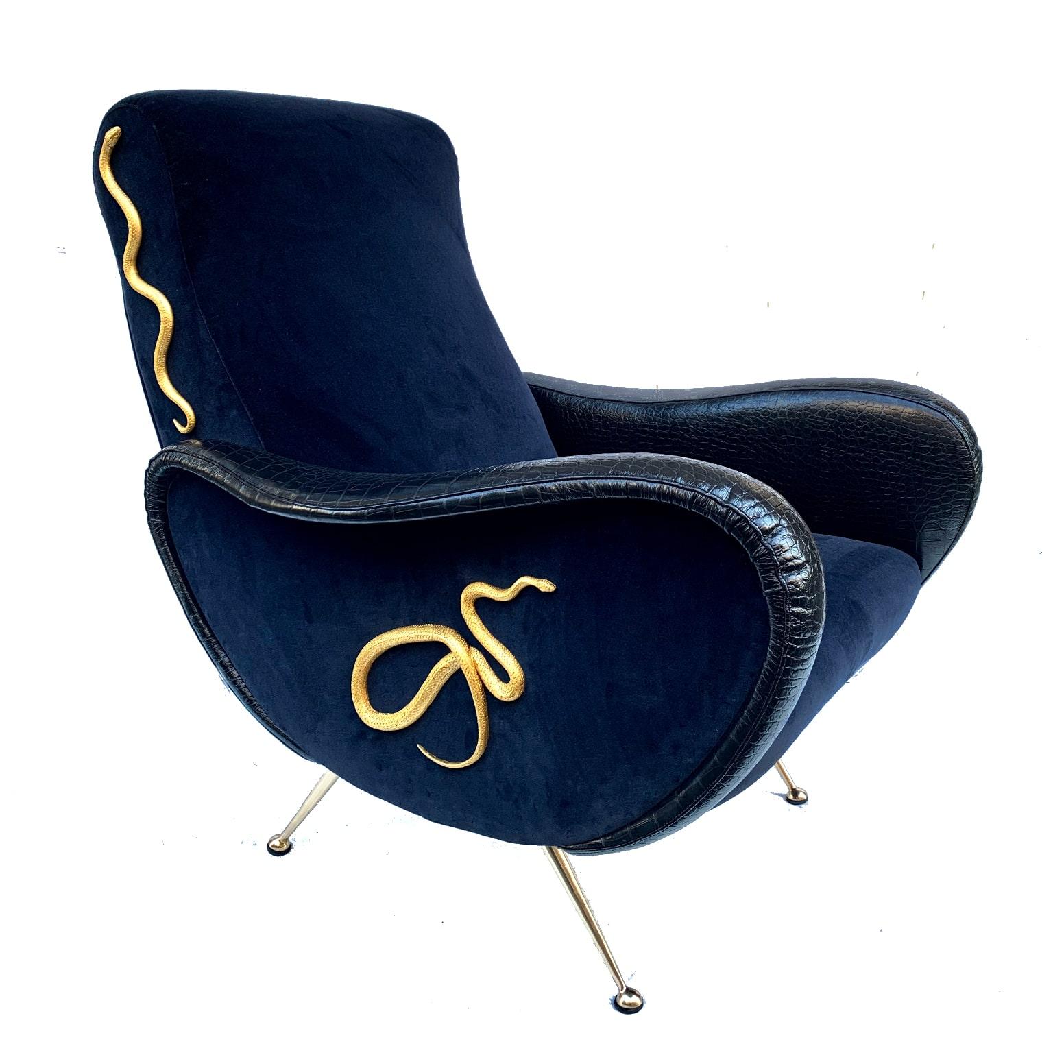 This armchair with footrest is a one-of-a-kind piece designed and realized by Giampiero Romanò, who melted the vintage style of the 60s with his creativity.
Upholstered with an electric dark blue velvet and reptile print leather on the armrests,