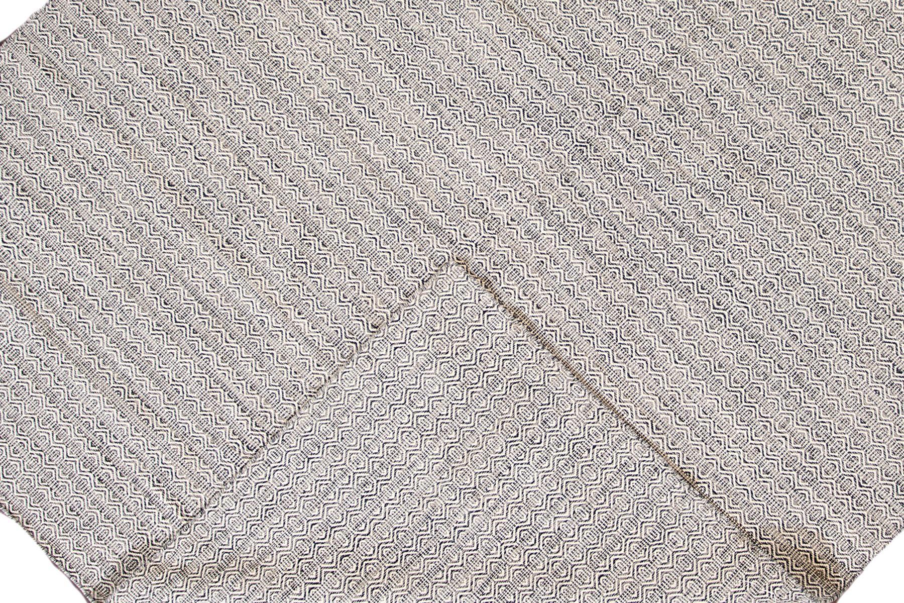 Tapis contemporain du 21e siècle, tissé à plat, avec un motif entièrement gris. Cette pièce présente des détails raffinés, de belles couleurs et un design magnifique. Il s'agit d'un complément idéal pour votre maison. Ce tapis mesure 10'1