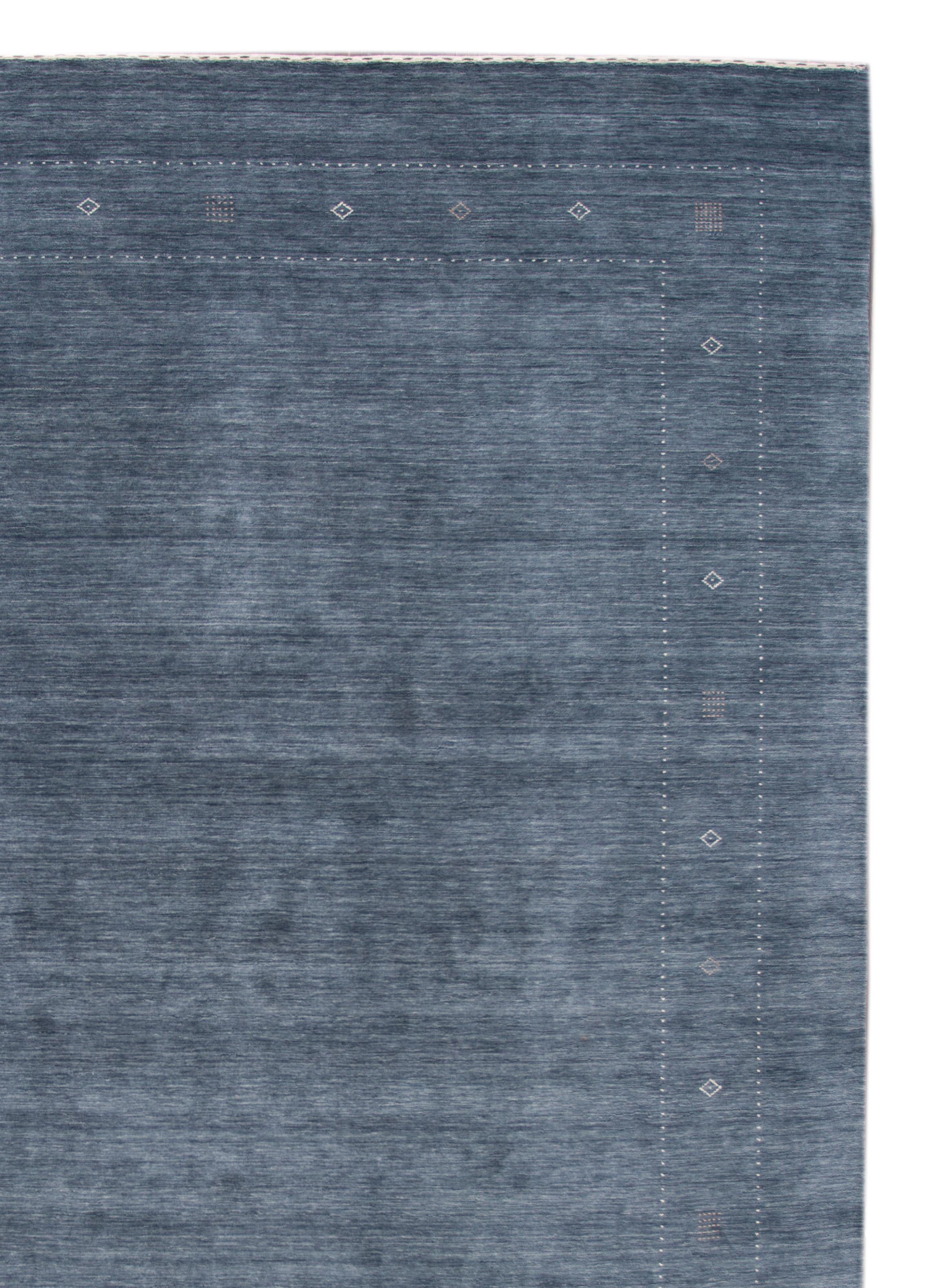 Moderner Gabbeh-Teppich des 21. Jahrhunderts mit einem blauen Farbfeld und dezenten elfenbeinfarbenen Akzenten.
Dieser Teppich misst 10' 0