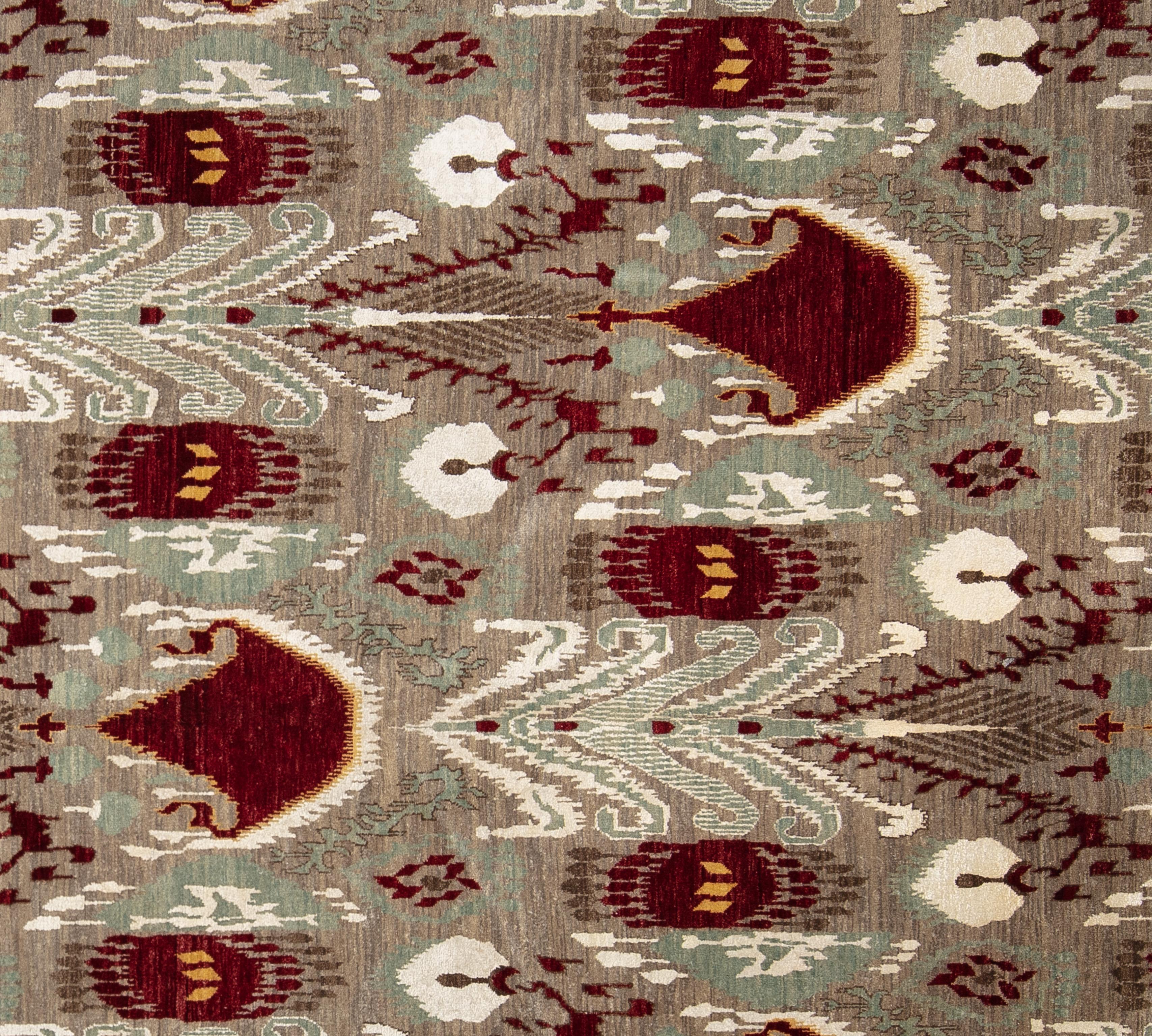Tissé à la main en Inde et composé à 100 % de laine, ce tapis amusant, moderne et sophistiqué présente une palette de couleurs vives. Doté d'un champ abrash taupe et gris et d'un motif captivant en all over cranberry, seafoam et ivory, ce tapis