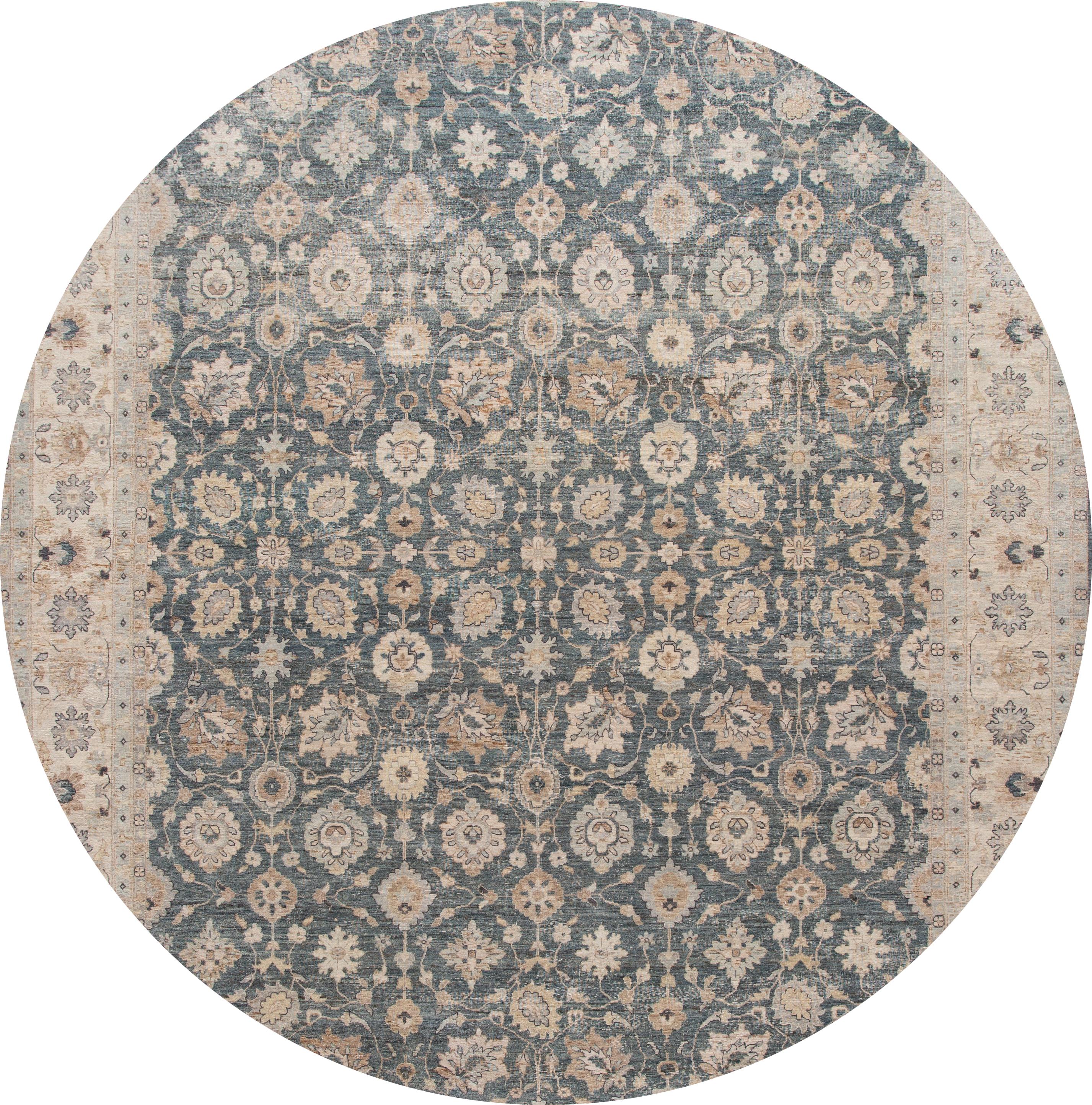 Schöner handgeknüpfter moderner indischer Wollteppich. Dieser Teppich hat ein blaues Feld mit einer hellbraunen Umrandung und floralen Mustern überall. 

Dieser Teppich misst 11' 10
