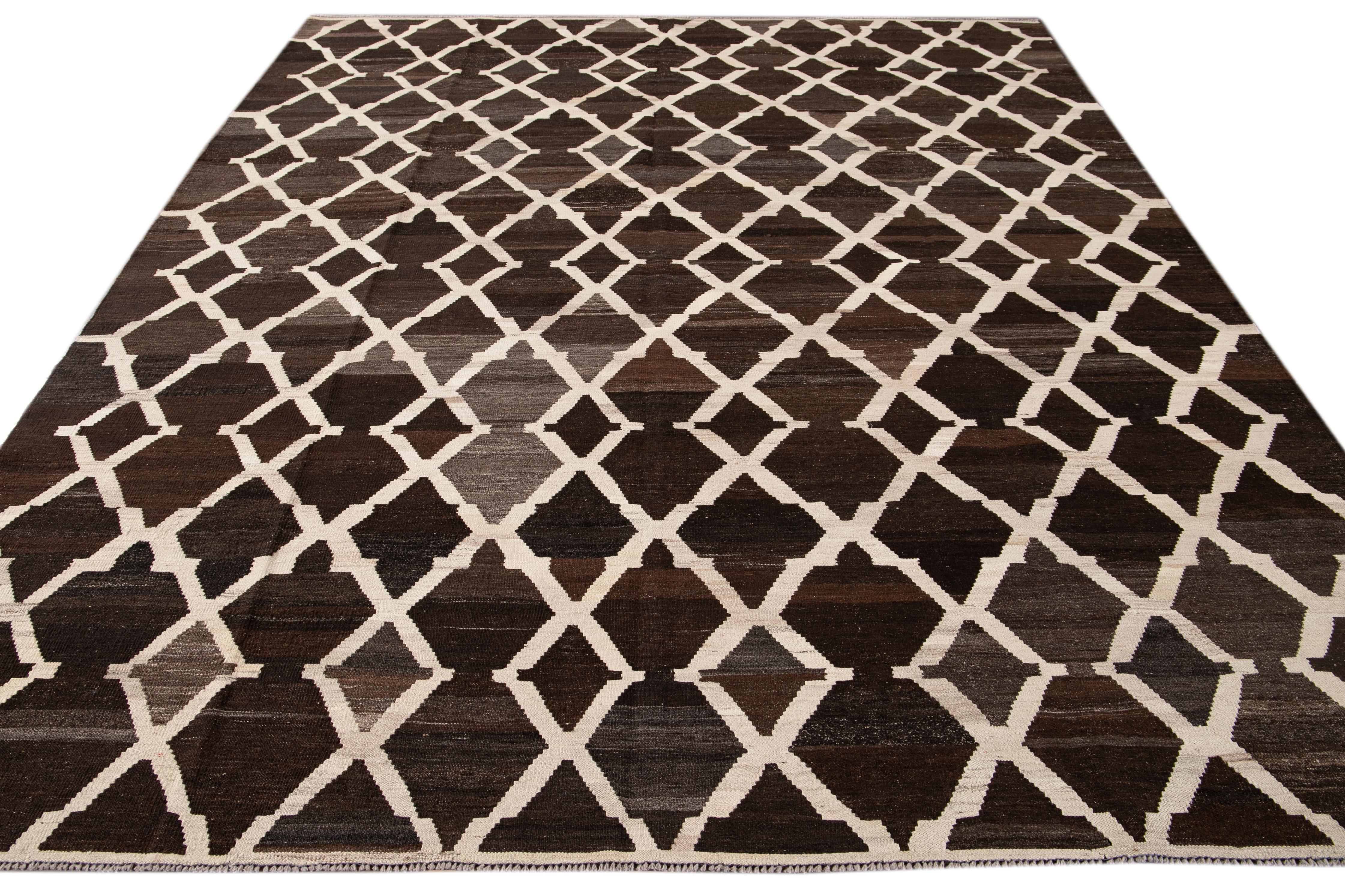 Beautiful hand-knotted flat-weave kilim wool rug. This rug has a dark brown field with ivory accents in an all-over tracery design.

This rug measures 8' 7