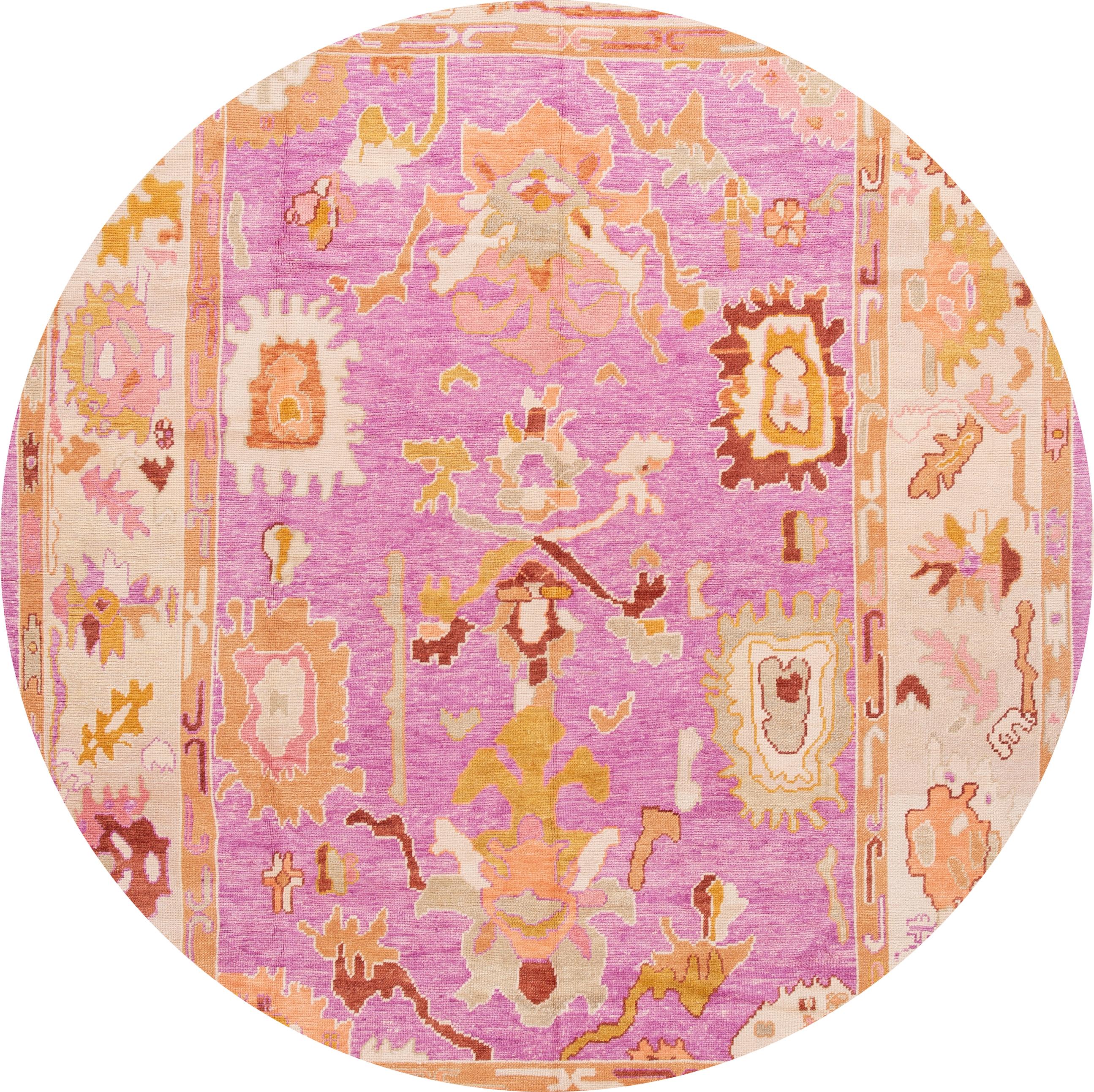 Beautiful Contemporary Turkish Oushak rug, hand knotted wool with a pink field, and multicolor accents in all-over geometric design,

This rug measures 8'9'' x 12'.