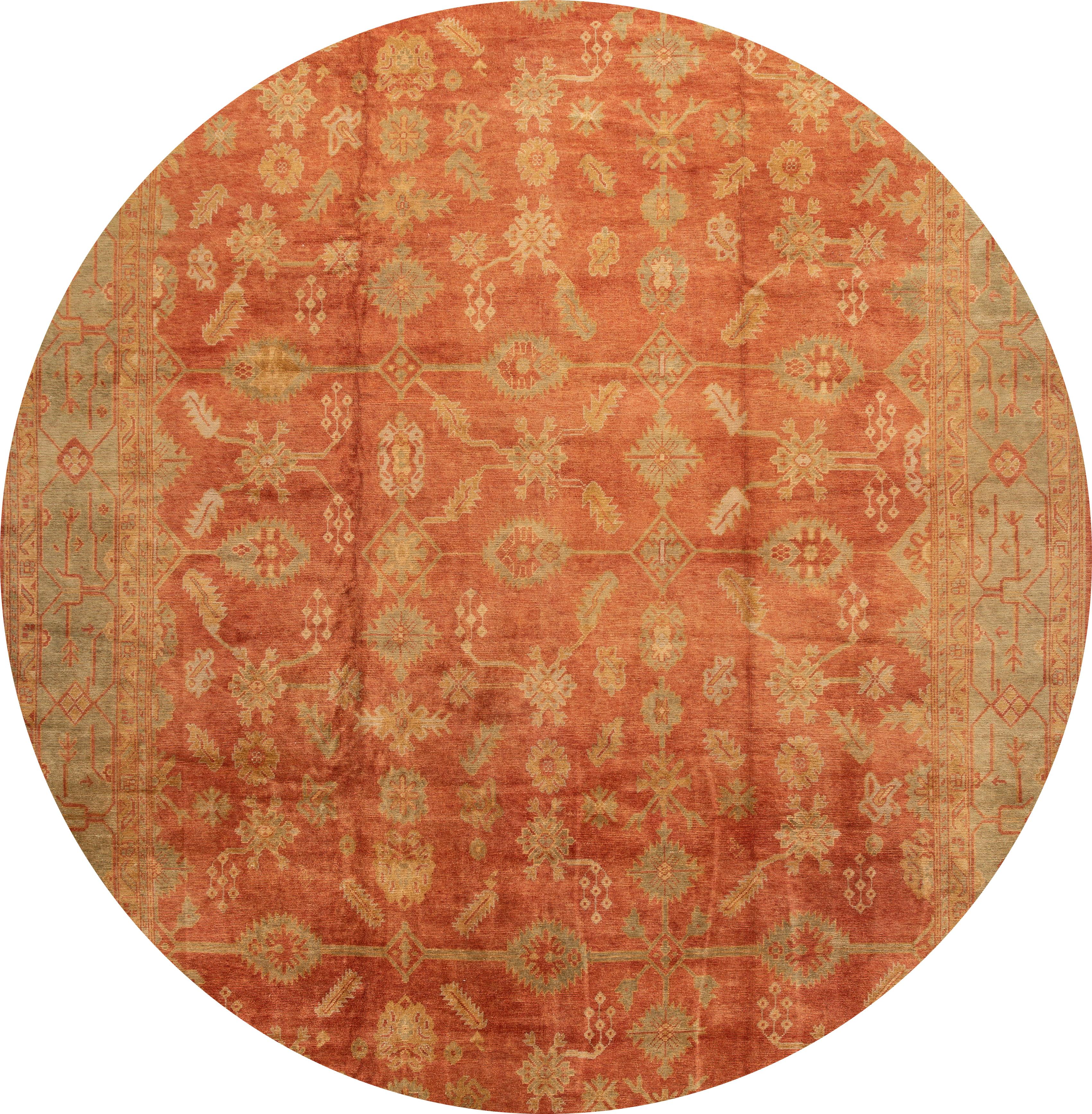 Beautiful modern oversize Oushak wool rug with an orange field, beige, and blue accents with an all-over floral design.

This rug measures 14' 4