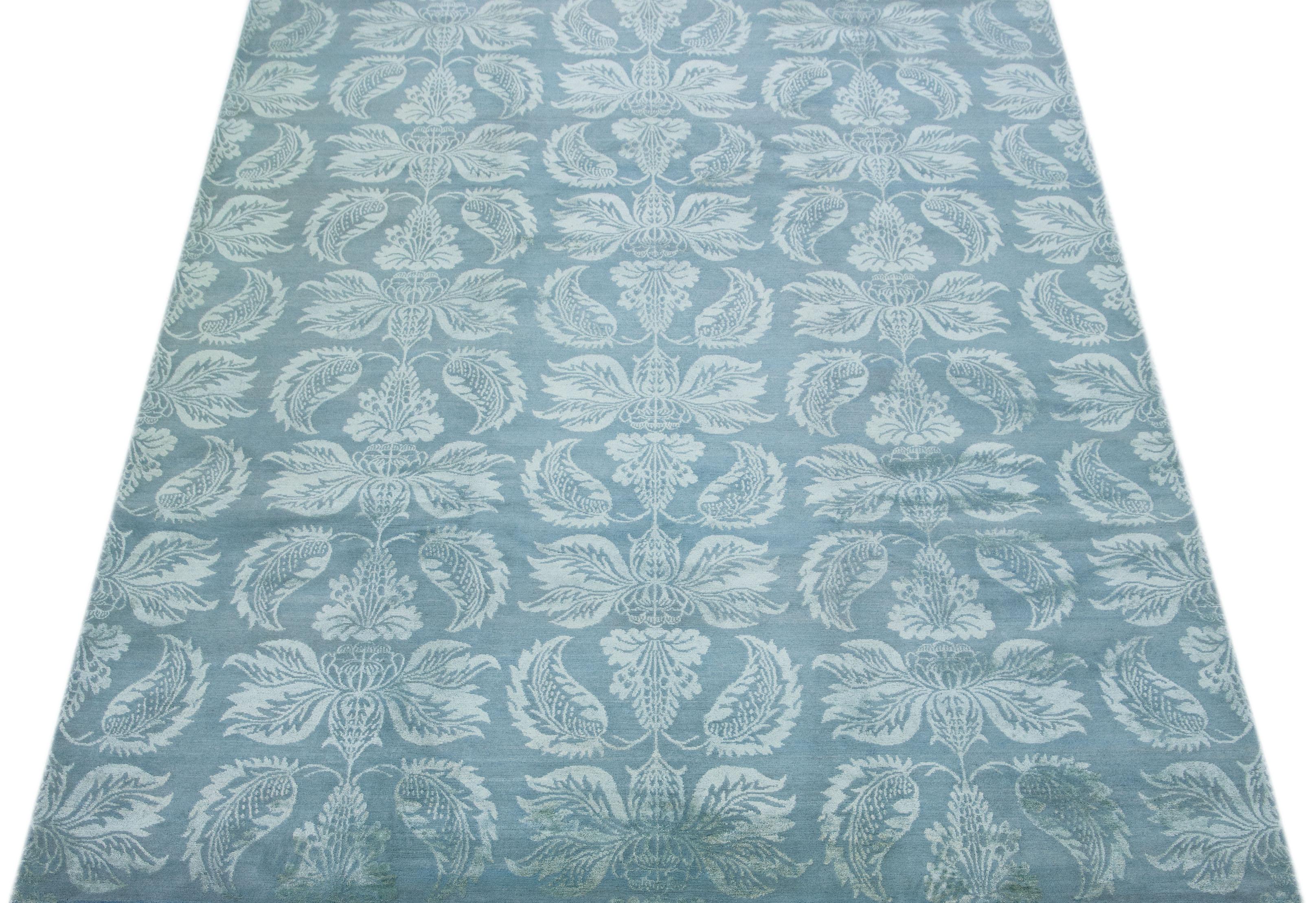 Ce tapis népalais contemporain est orné d'un motif floral bleu clair qui s'étend sur toute sa surface. Ses détails complexes et sa palette de couleurs éclatantes en font une pièce magnifique. Pensez à ajouter ce tapis à votre décoration intérieure