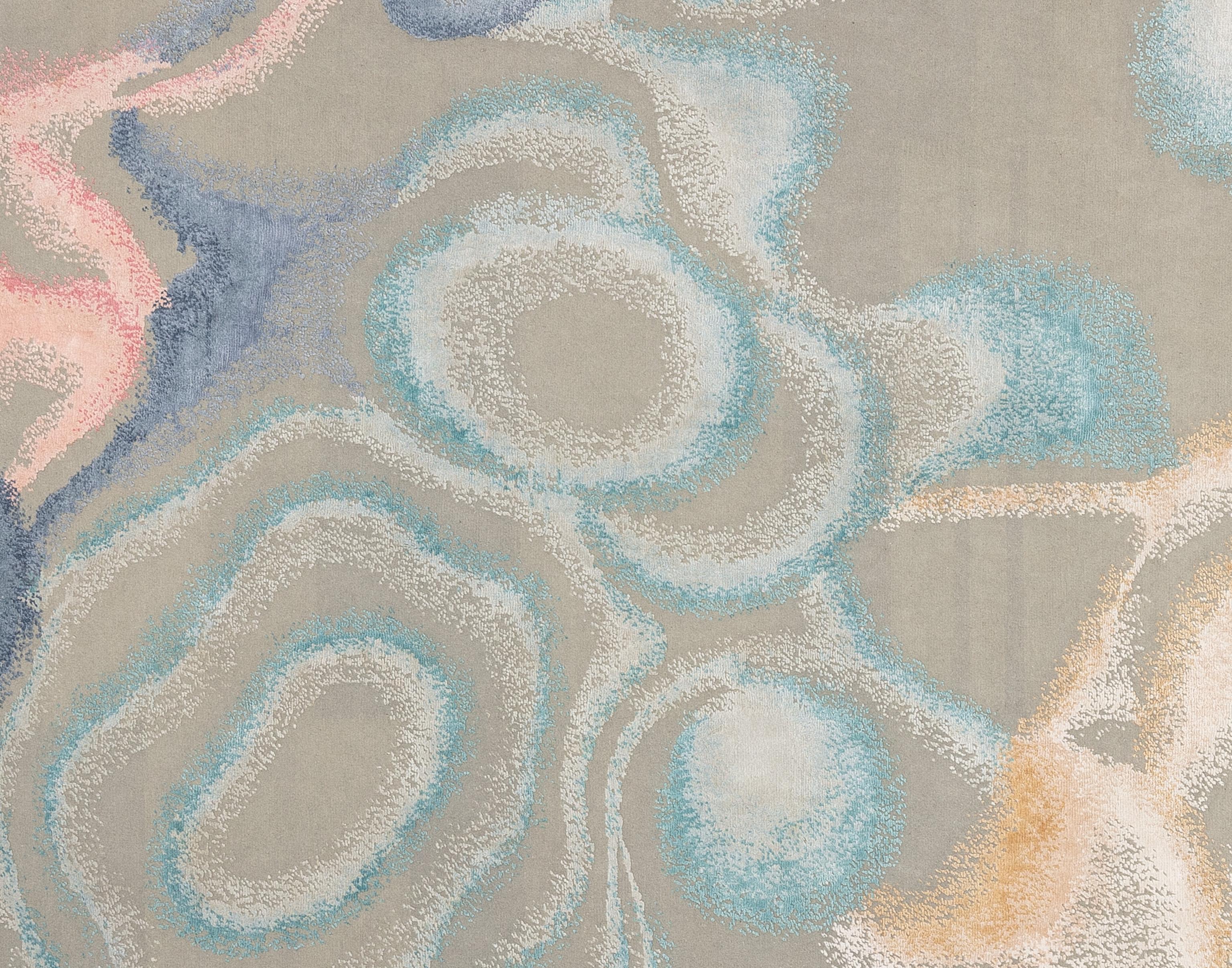 Enhance your home with this beautiful contemporary rug, meticulously handcrafted in India. This exquisite piece features a stunning array of tones, creating a visually captivating centerpiece for any room. The blend of premium silk and wool fibers