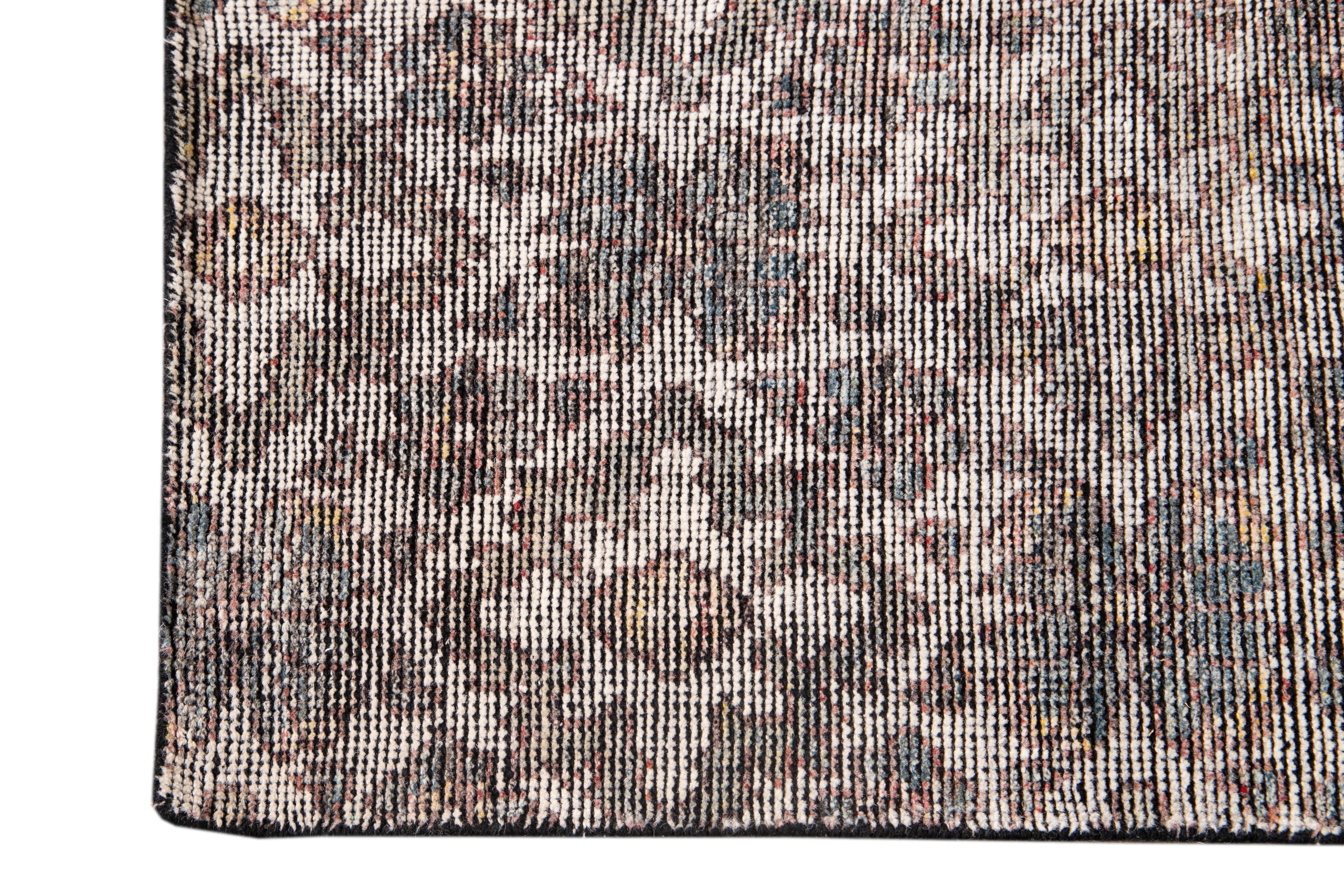 Bellissimo tappeto indiano moderno in stile Soumak, annodato a mano in lana con campo grigio, accenti avorio e ruggine in un disegno floreale a più medaglioni, circa 2019.
Questo tappeto misura 8' 2
