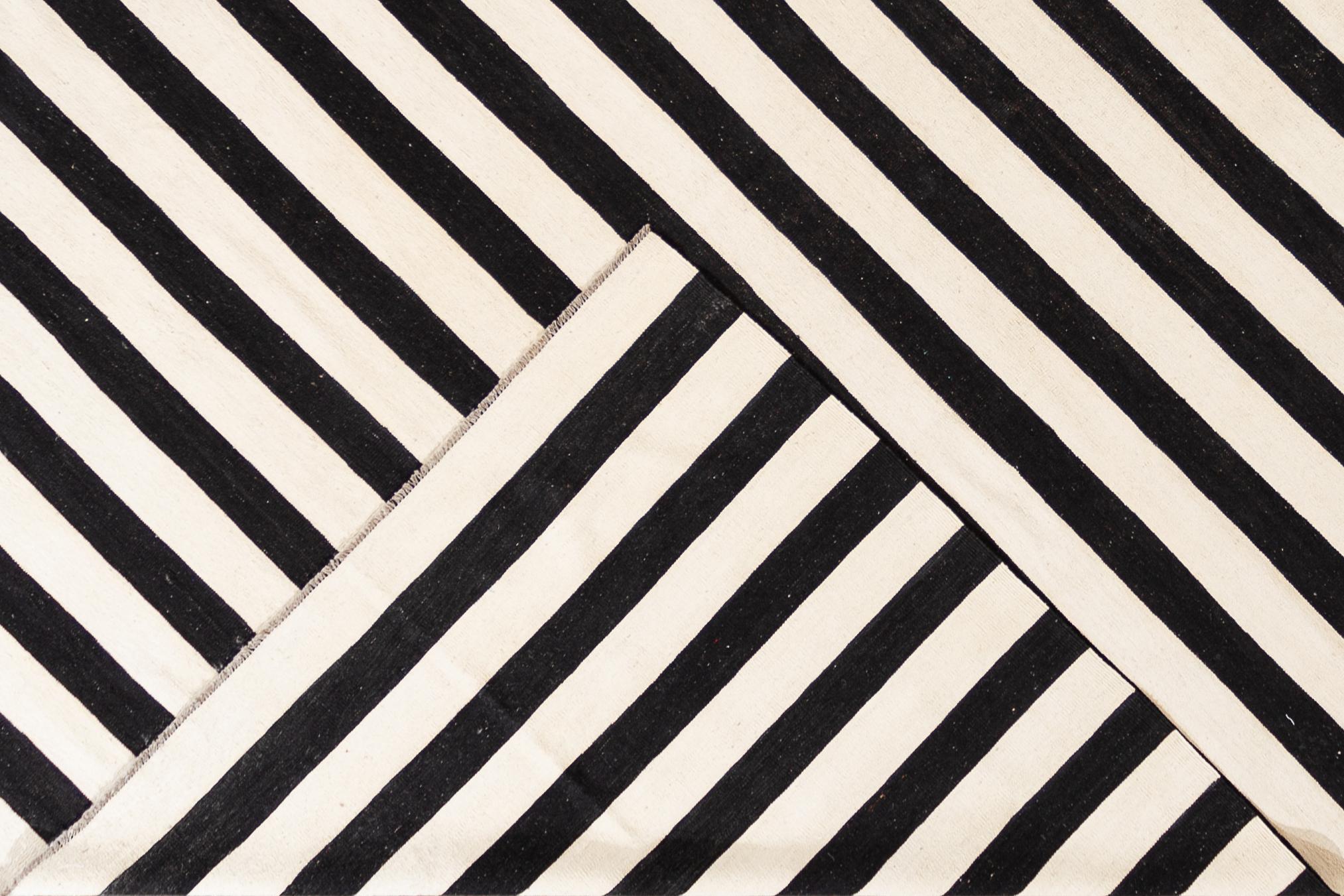 A contemporary oversize black and white striped Kilim rug. This hand-woven flatweave wool rug measures 12'4