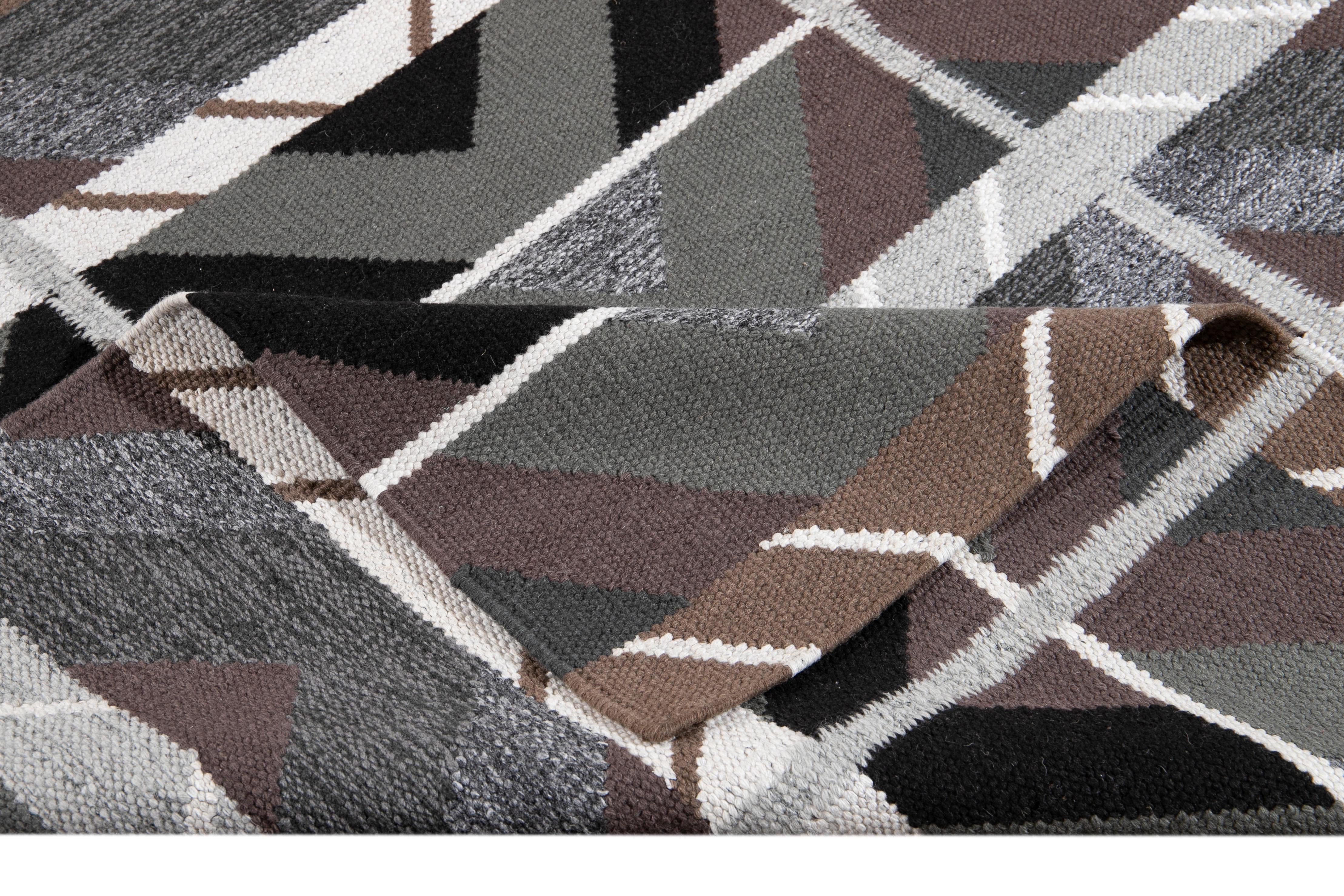 Beautiful modern Swedish style rug with a gray field, purple, ivory, and brown accents, with an all-over geometric design. 

This rug measures 10' 3
