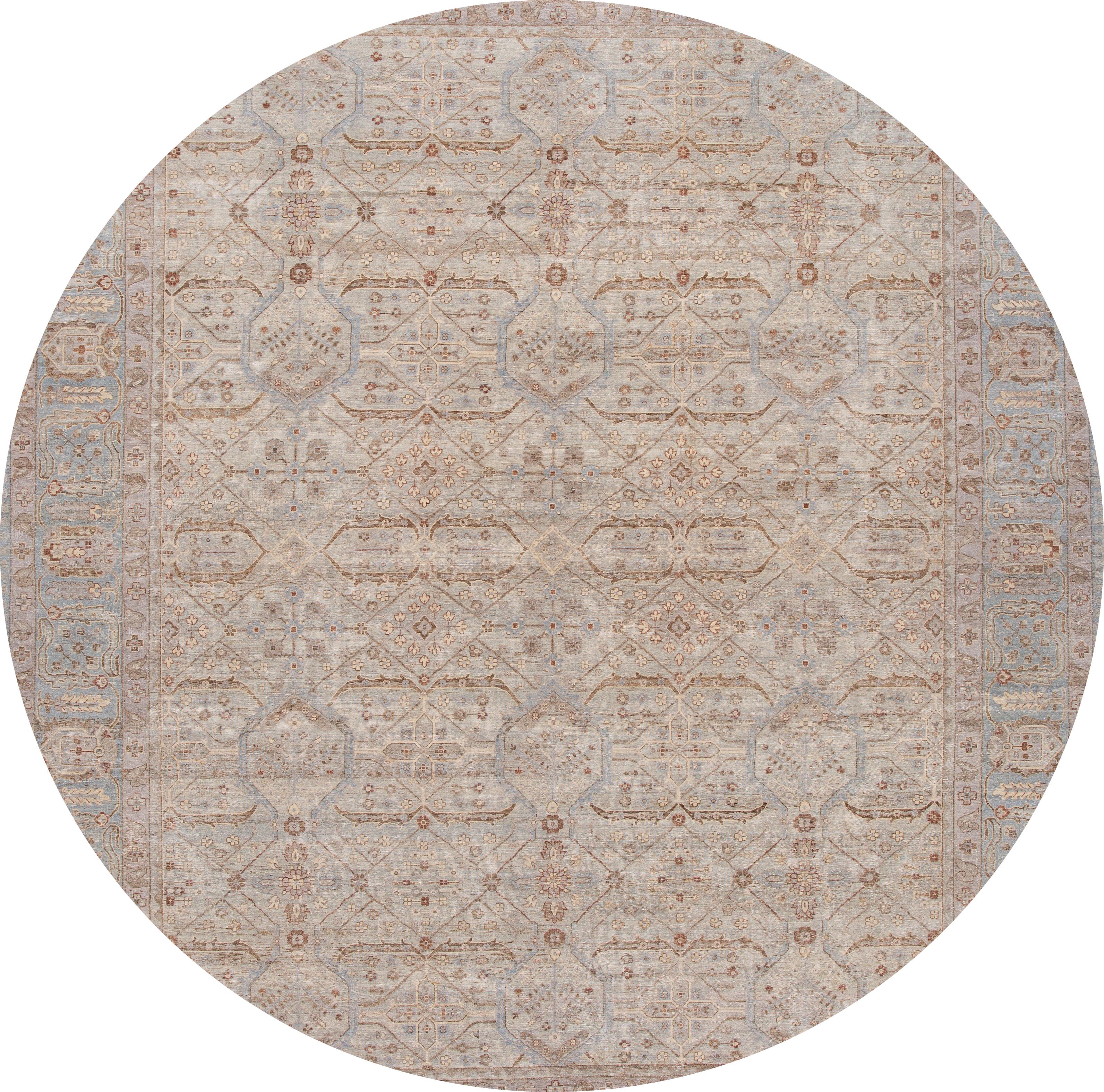 A contemporary Tabriz style rug with a tan field and ivory and blue accents in a symmetrical, interconnected floral and vine design. This hand knotted wool.
This rug measures: 12'1