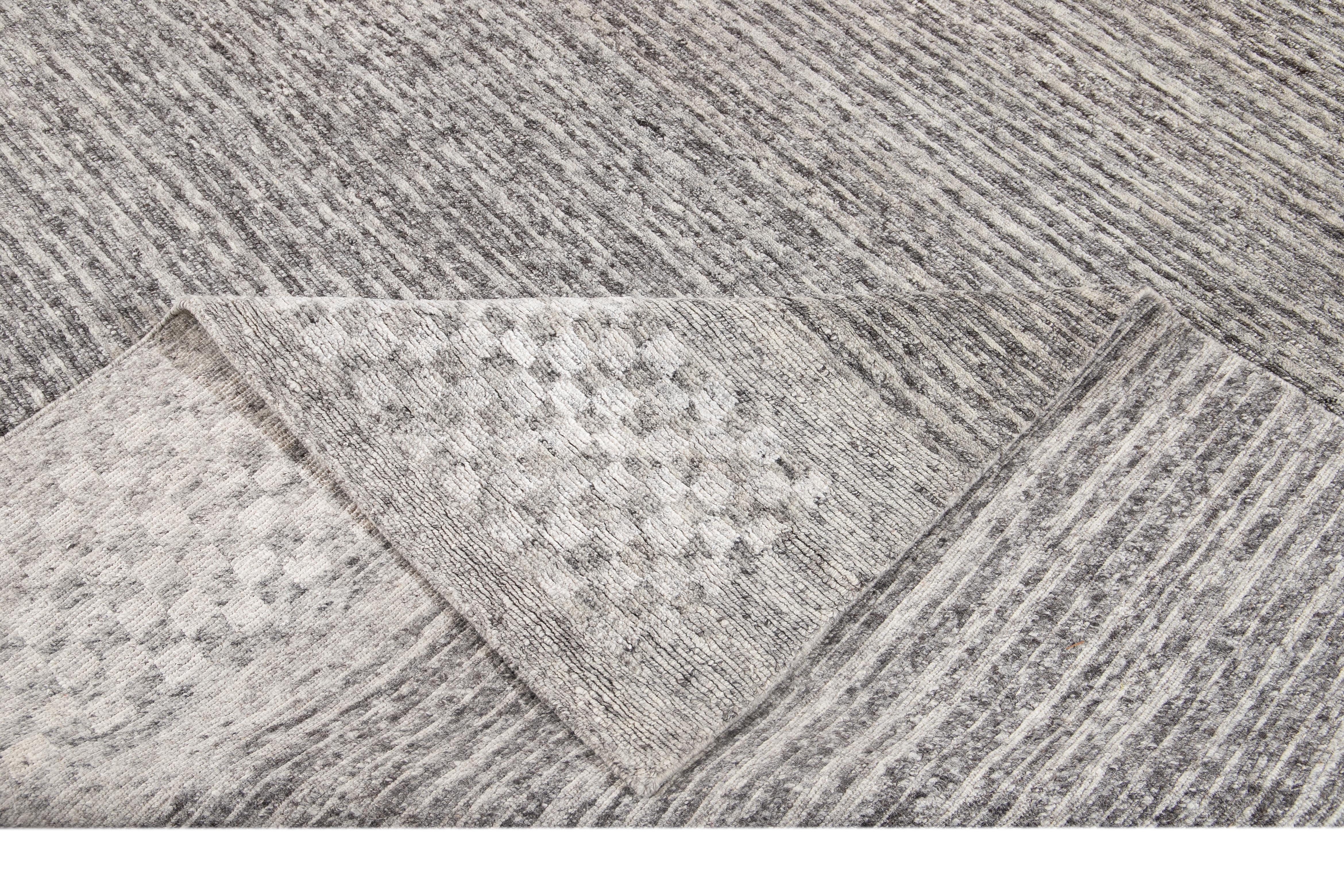 Beautiful modern textured loop Indian rug, hand-knotted wool with a gray field, dark gray and ivory accents, with checkered borders. 

This rug measures 12' 0