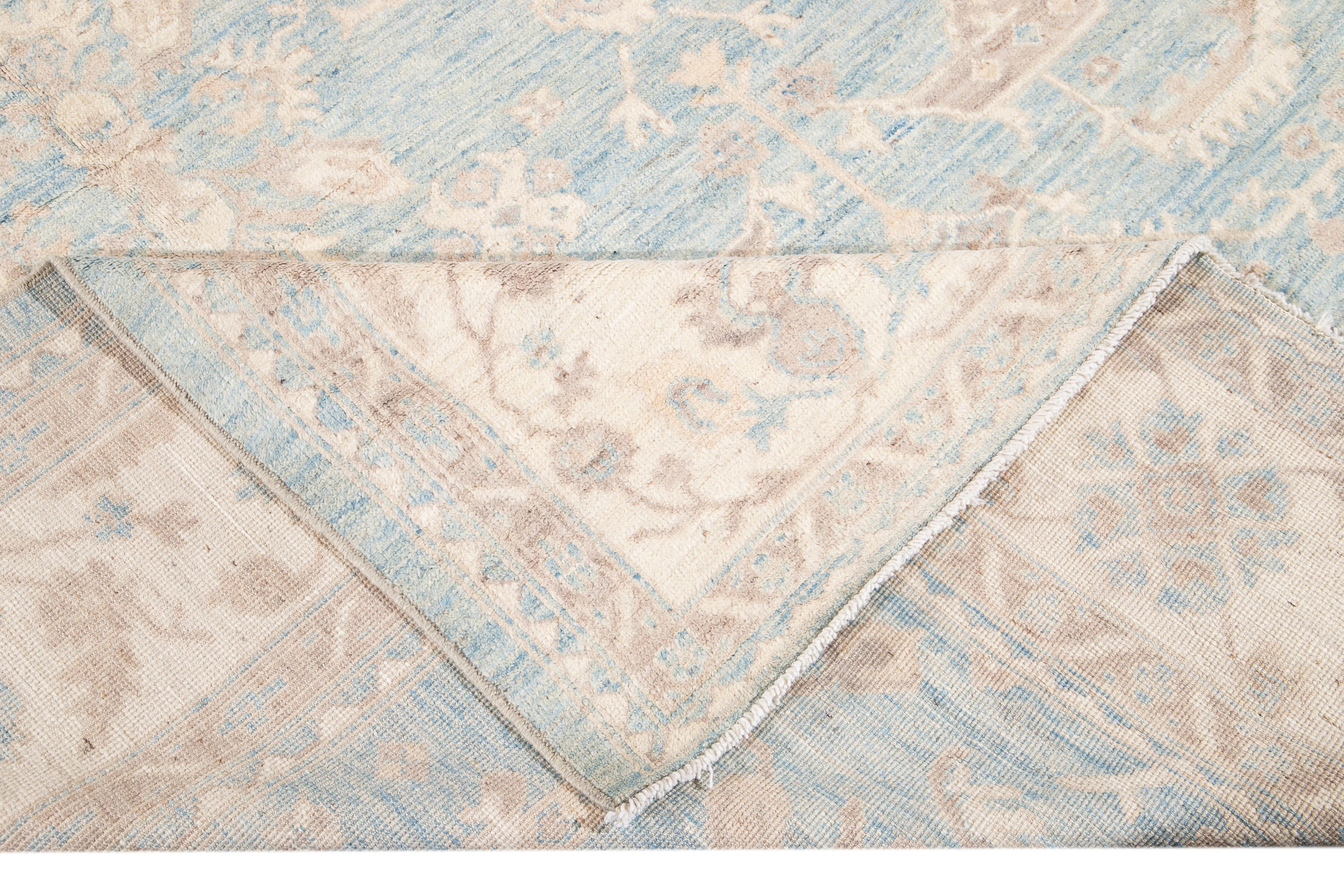 Beautiful modern Turkish Oushak wool rug with a light blue field. This Turkish rug has a beige frame and brown accents featuring a gorgeous all-over floral design. 

This rug measures 10' 1
