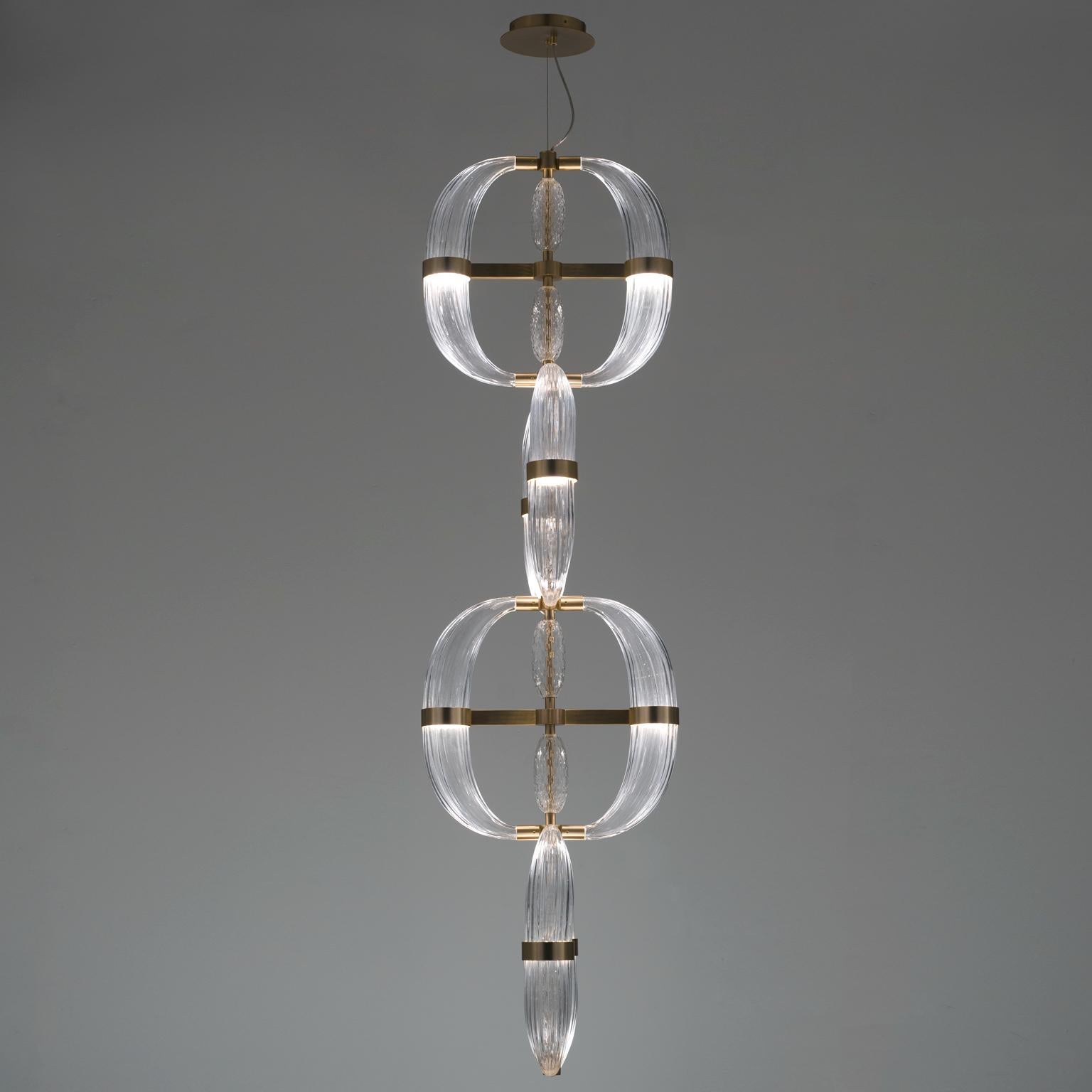 Love at first sight between glass and metal. A light cascade suited for a vertical or horizontal development, according to the needs. One, two or many elements. The imperfect, organic and sinuous lines of the hand blown glass are contrasted by a