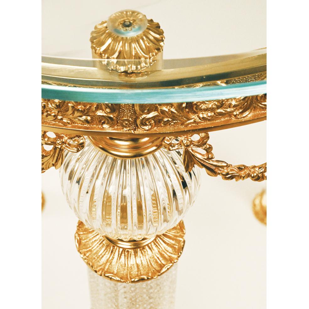 Clear crystal and French gold bronze side table with three legs and the temperated glass top. The parts in crystal are hand-carved. Each object is handcrafted and the care for every detail makes each item unique in its kind. The style of this side