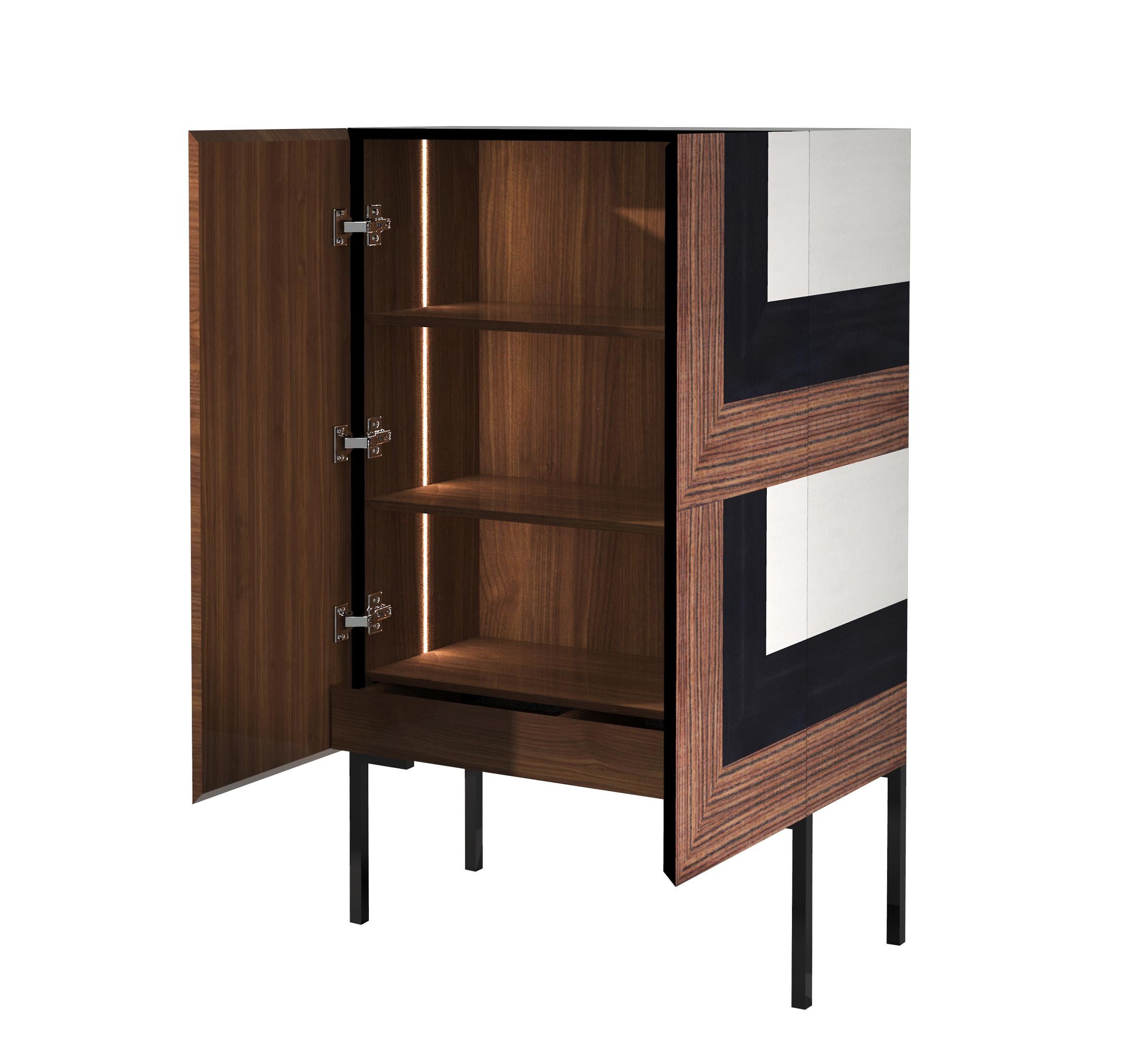 Combined by Hebanon's master cabinet-makers, the woods are skilfully juxtaposed to design a refined optical inlay.

The frontal perspective illusion is reinforced by the 45° cut of the doors and structure that allows the precious woods to be