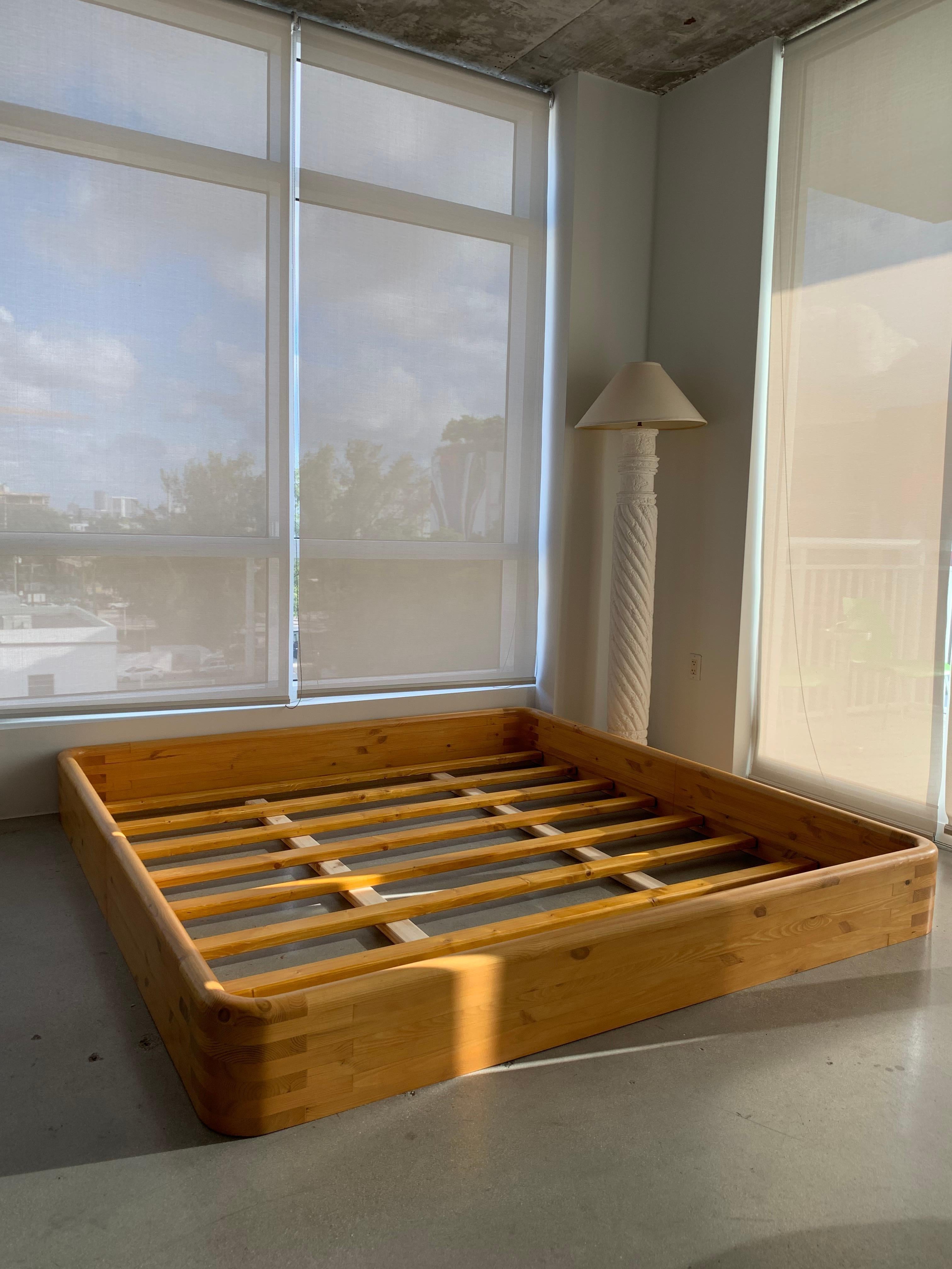 21st century custom bentwood king bed frame handcrafted in Jupiter Florida. Beautiful layered pine sanded and stained a lovely light natural color with waterfall edges and a round beveled rim. Perfect low profile bed with interior slat boards for
