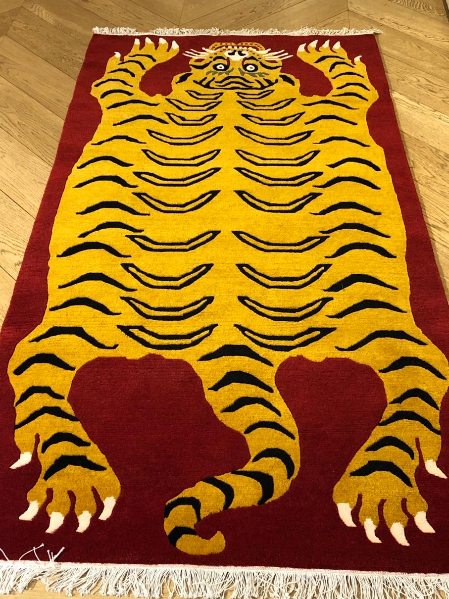 Tiger rug cm. 180 x 90 new production Nepalese rug, knotted with hand-spun wool with Tibetan knot. The background is a brilliant red and the tiger depicted has its back richly decorated in the traditional yellow of the fur of these felines. The face