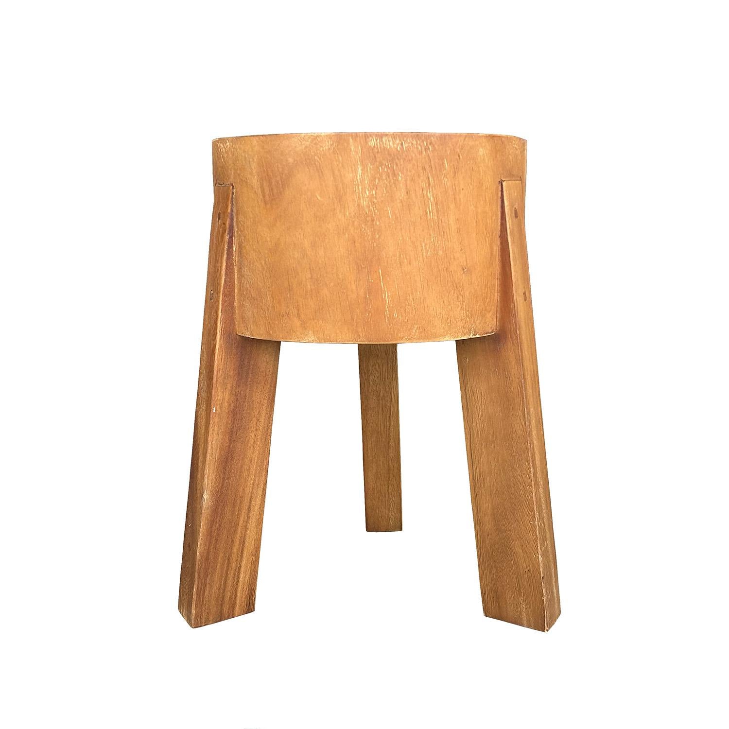 Tabouret danois sculpté dans un bois tropical au grain fin et à la finition brossée. Le siège a une assise très épaisse et trois pieds. La finition peut varier. Usure conforme à l'âge et à l'utilisation. Circa 21st Century, Denmark, Scandinavia.