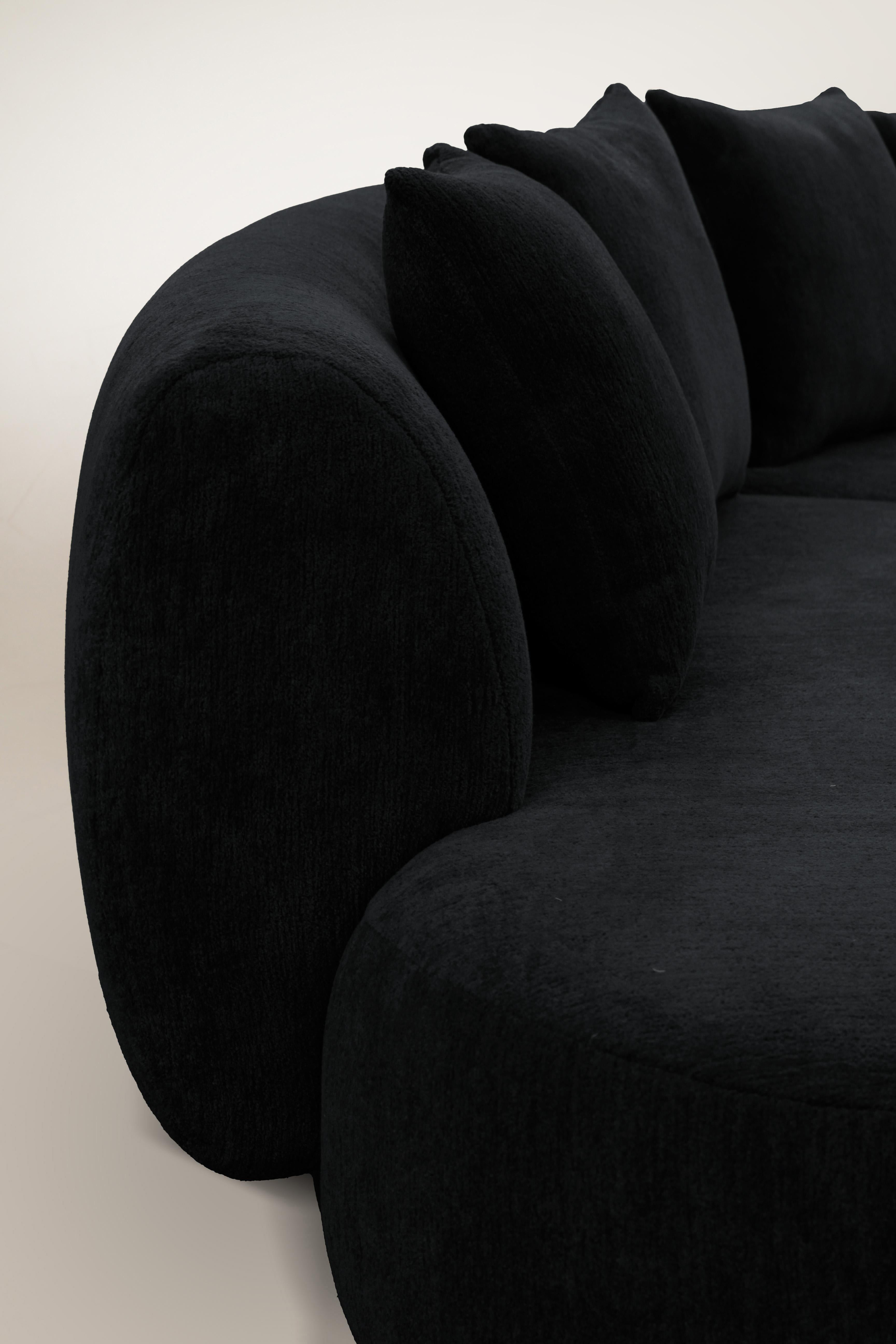 Le canapé Hug se caractérise par des lignes simples et épurées et un accoudoir distinctif.
L'accoudoir, qui chevauche à moitié le coussin d'assise, crée un détail d'emboîtement entre les deux éléments, tandis que le padding, ferme et accueillant à