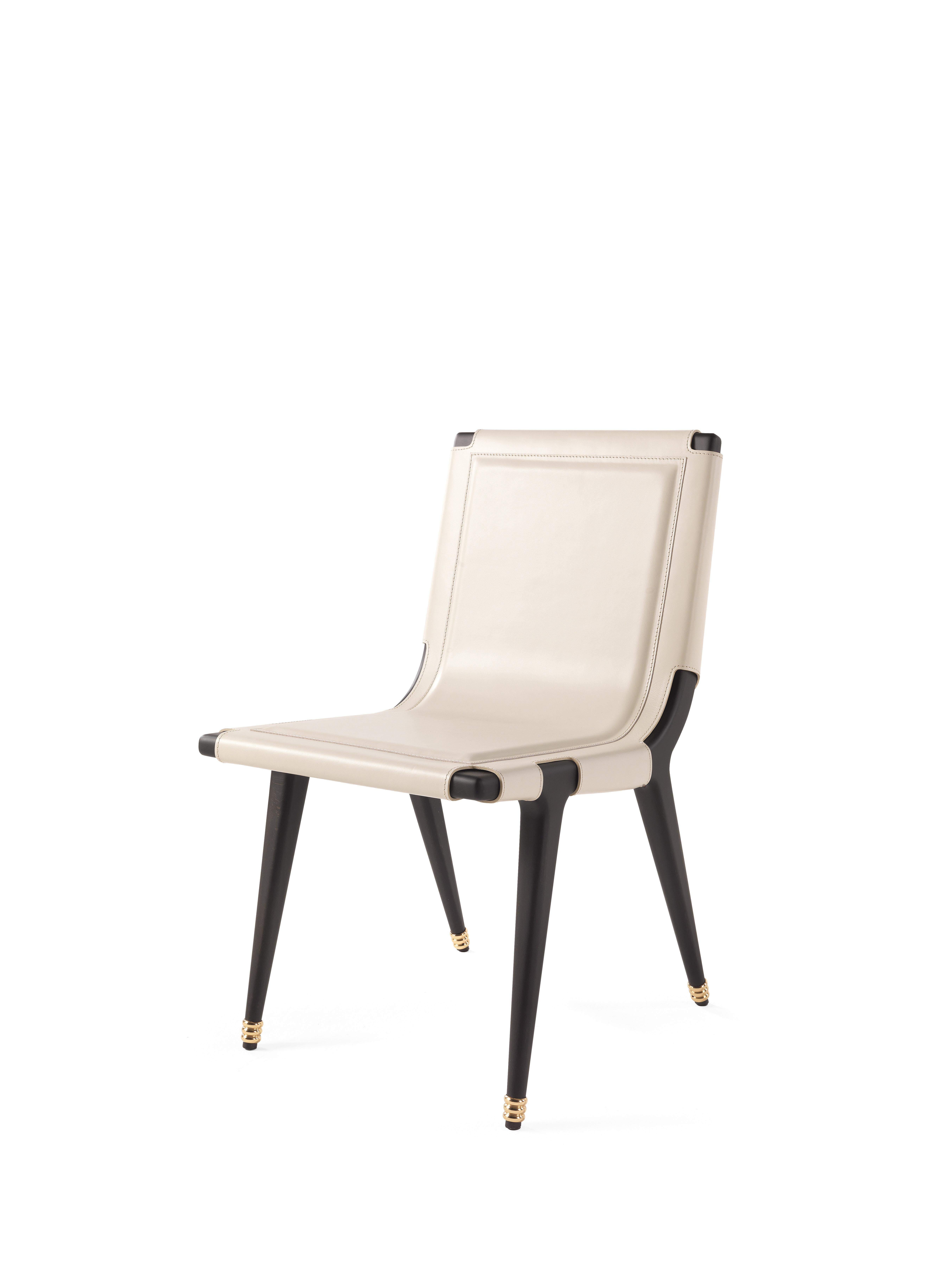 Dinka is a chair full of fascinating details and evocative references.
The precious upholstery in ivory saddle leather features special eyelets lace-up on the back.
The structure with matt dark wengé dye is enriched by polished brass rings,