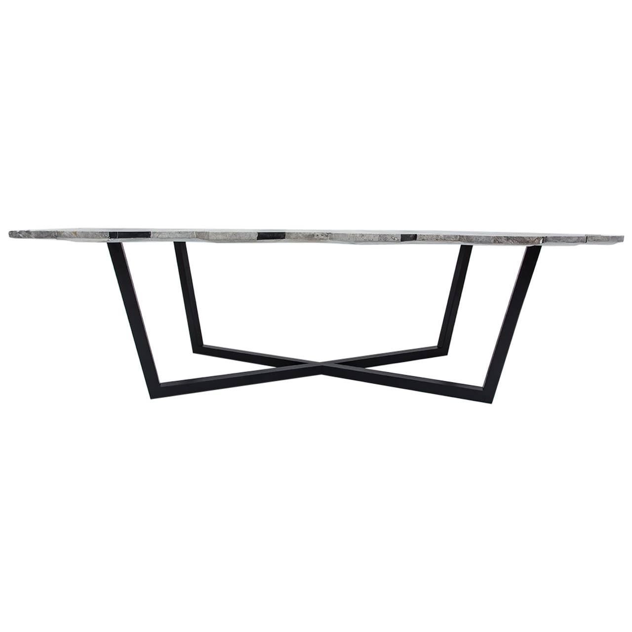 La table basse IDEA est née de l'idée de créer un objet véhiculant une illusion d'optique. L'effet stéréographique est obtenu en combinant différents types de marbre. La forme asymétrique du plateau de marbre ajoute à l'illusion de diplopie. Les