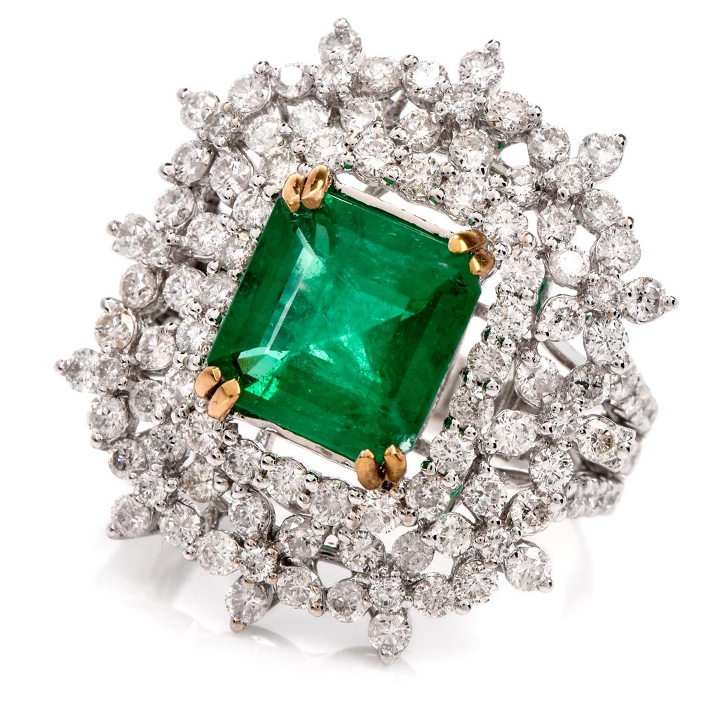 This stunning emerald and diamond cocktail ring crafted in 18-karat white gold. Centered is an emerald-cut emerald weighing approx. 2.87 carats. Contrasted by a shimmering double halo of flower patterned and round-cut diamonds weighing approx. 3.02