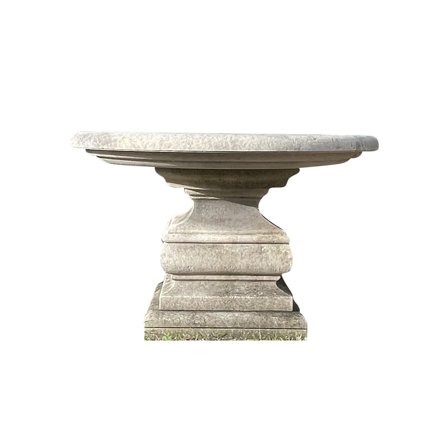 Mesa circular tallada a mano con una imponente base cuadrada biselada múltiple. La gruesa parte superior redondeada tiene un bello diseño tallado que representa una flor con ocho pétalos. Los pétalos se han martillado en la piedra caliza natural,