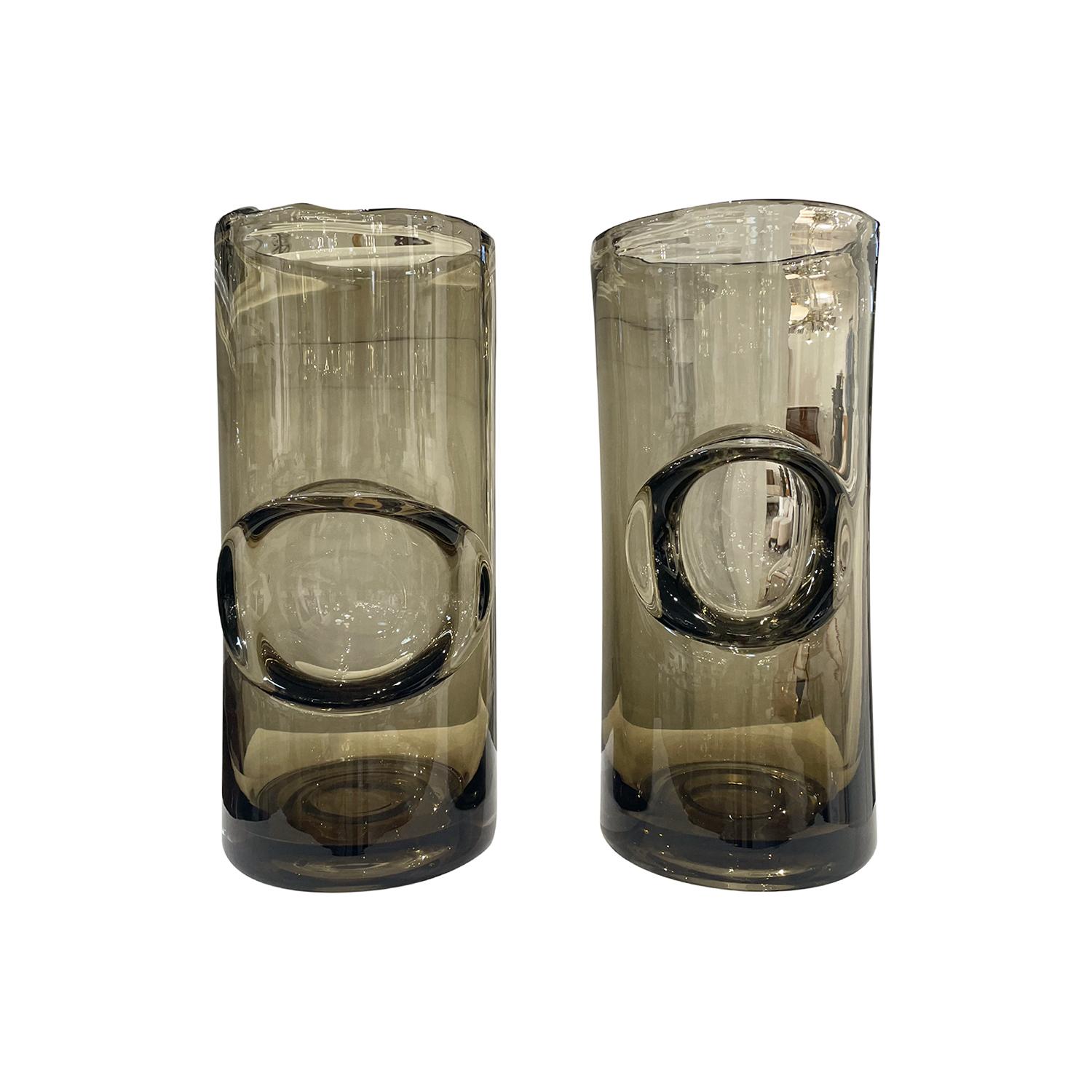 A pair of mouth blown crystal glass vases with a contemporary large irregular bubble décor. The heavy cylinder shaped crystal glass object has an artistic inclusion of an iridescent smoke color. A unique handmade design adds to the extraordinary and