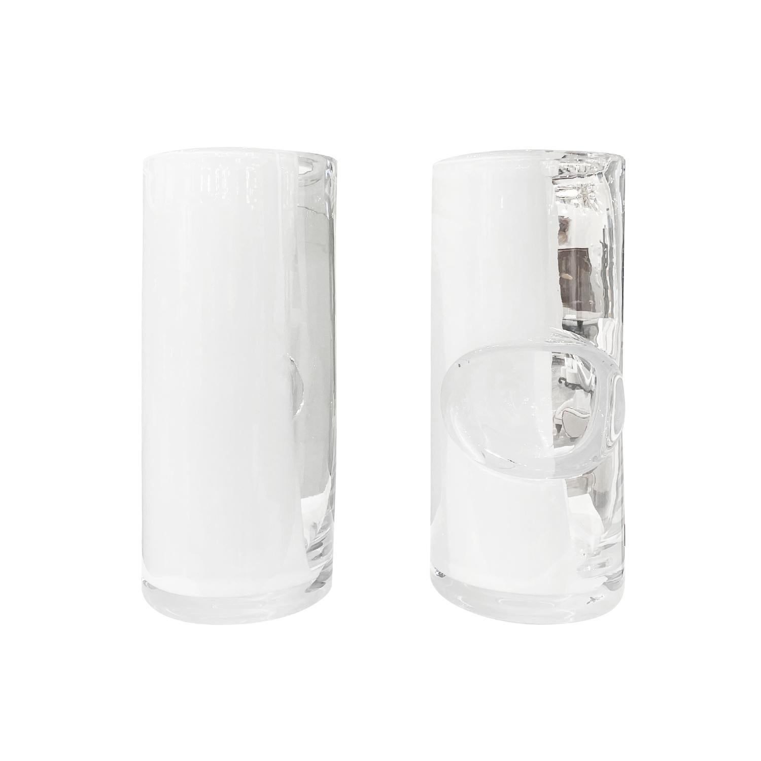 A pair of mouth blown crystal glass vases with a contemporary large irregular bubble décor. The heavy cylinder shaped crystal glass object has an artistic inclusion of white inserted into the transparent vase. The unique handmade design adds to the