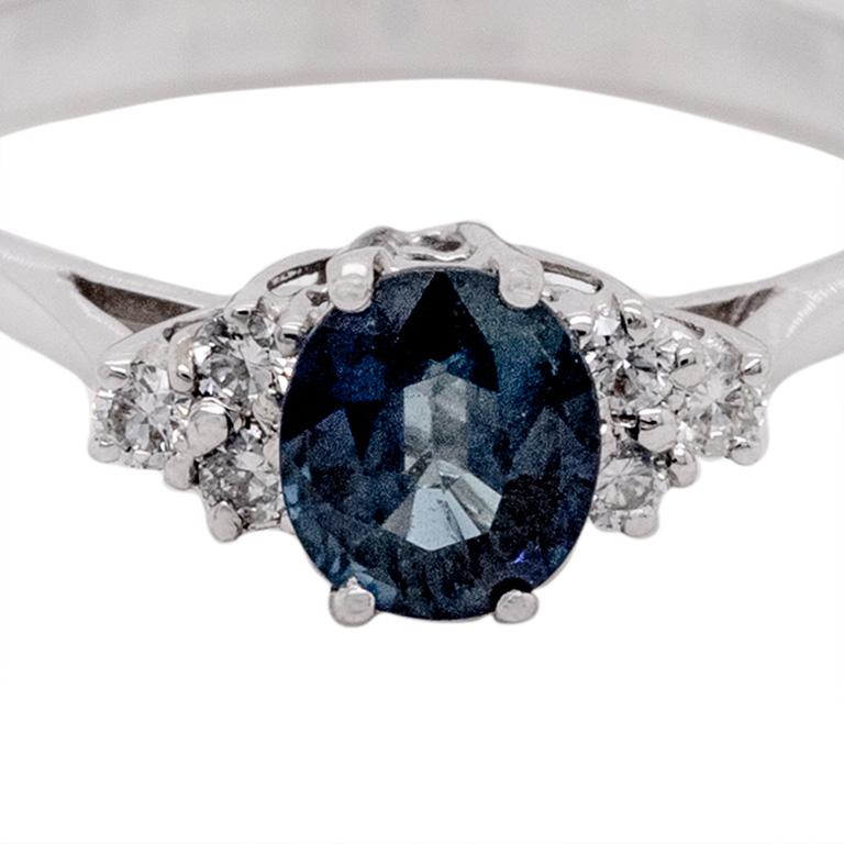 Adorn your finger with the enchanting beauty of this exquisite 18-karat white gold ring. The focal point of this captivating piece is a brilliant oval cut sapphire, boasting a mesmerizing carat weight of 0.86. Enhancing the allure of the central