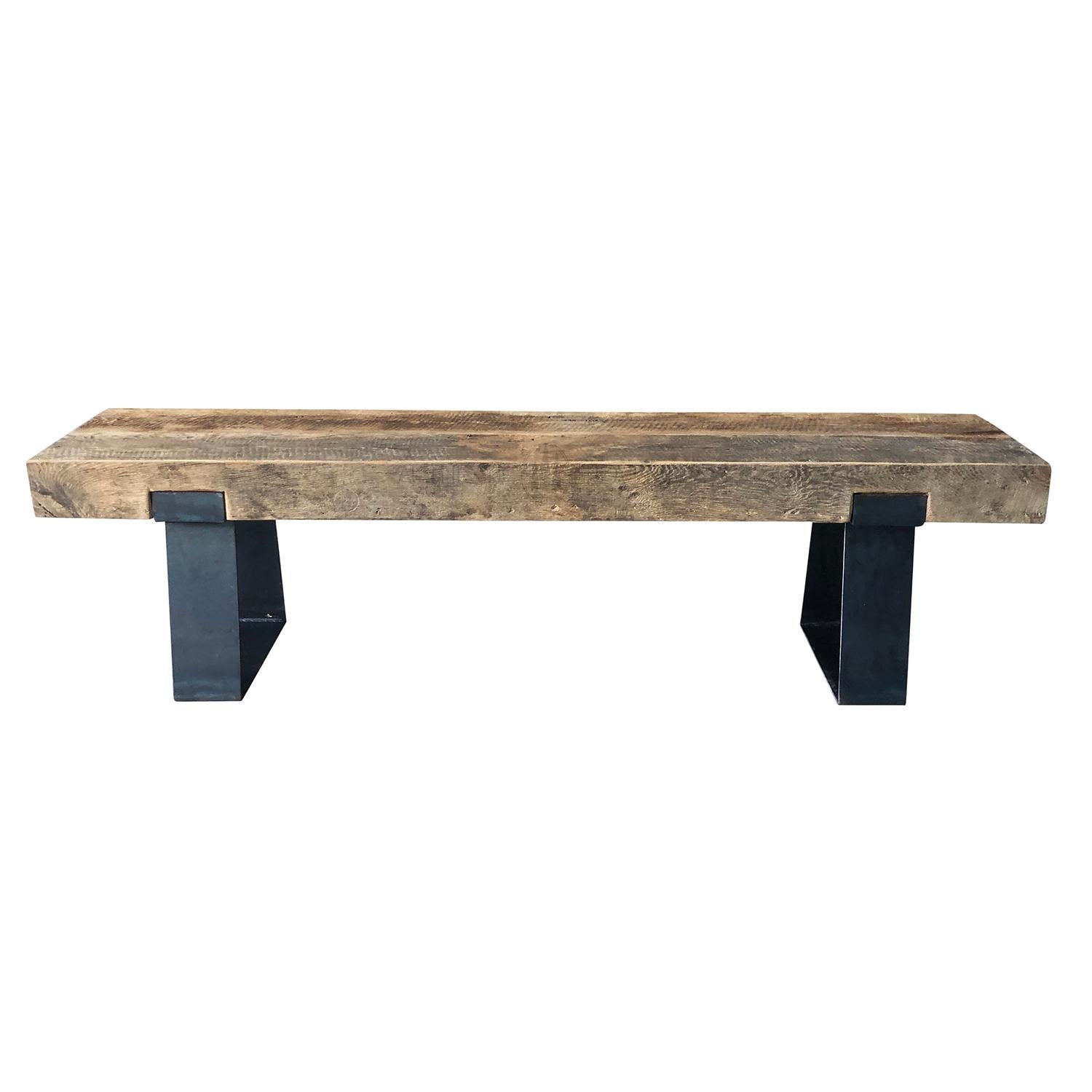 Banc industriel minimaliste composé d'une seule pièce de chêne français massif ciré en combinaison avec de larges pieds en métal contemporains forgés à la main. Usure conforme à l'âge et à l'utilisation.