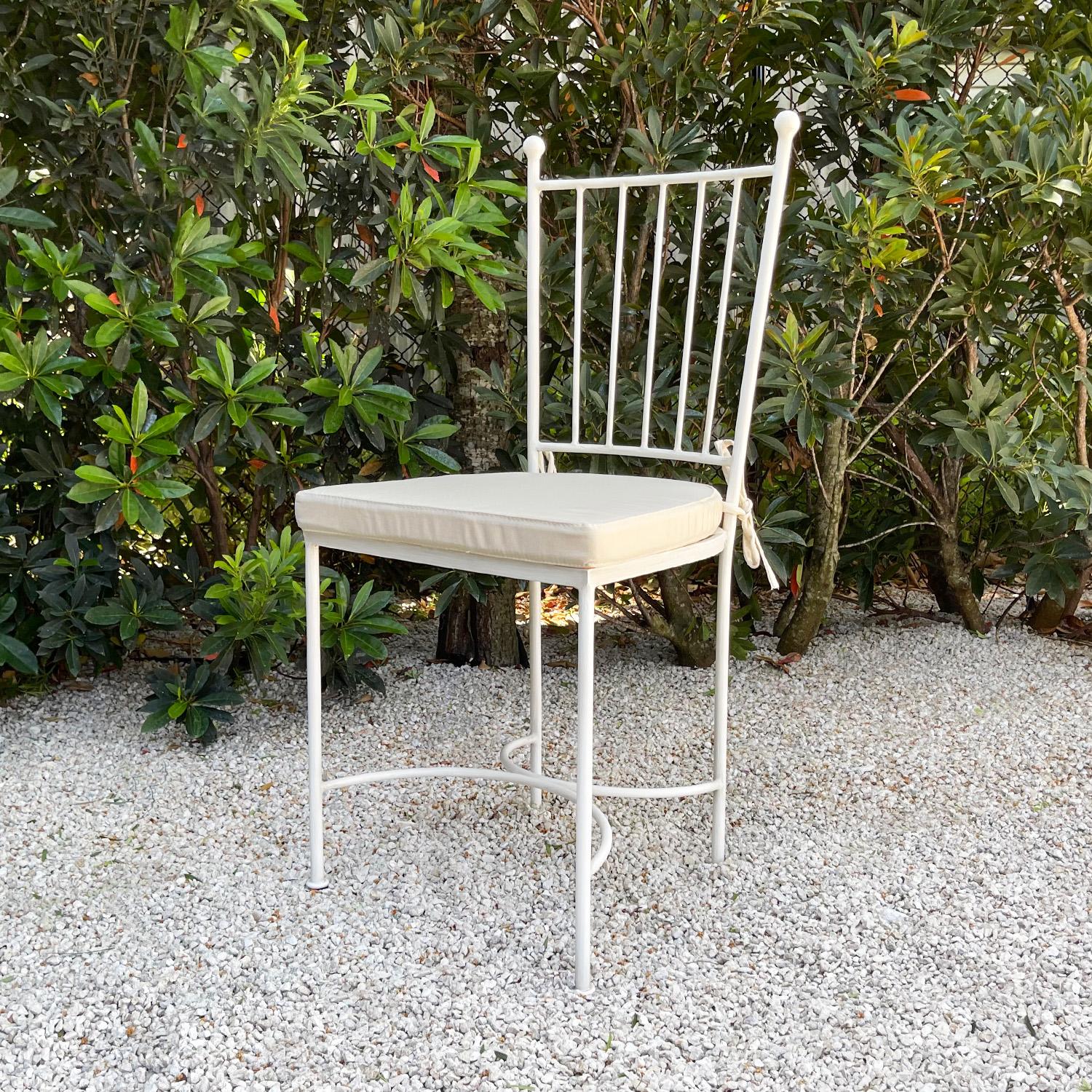 Una silla auxiliar francesa inspirada en los encantadores muebles de jardín europeos de los siglos XIX y XX. El respaldo vertical está rematado por esferas y los anchos listones metálicos del asiento tienen una pátina blanca lavada con pintura