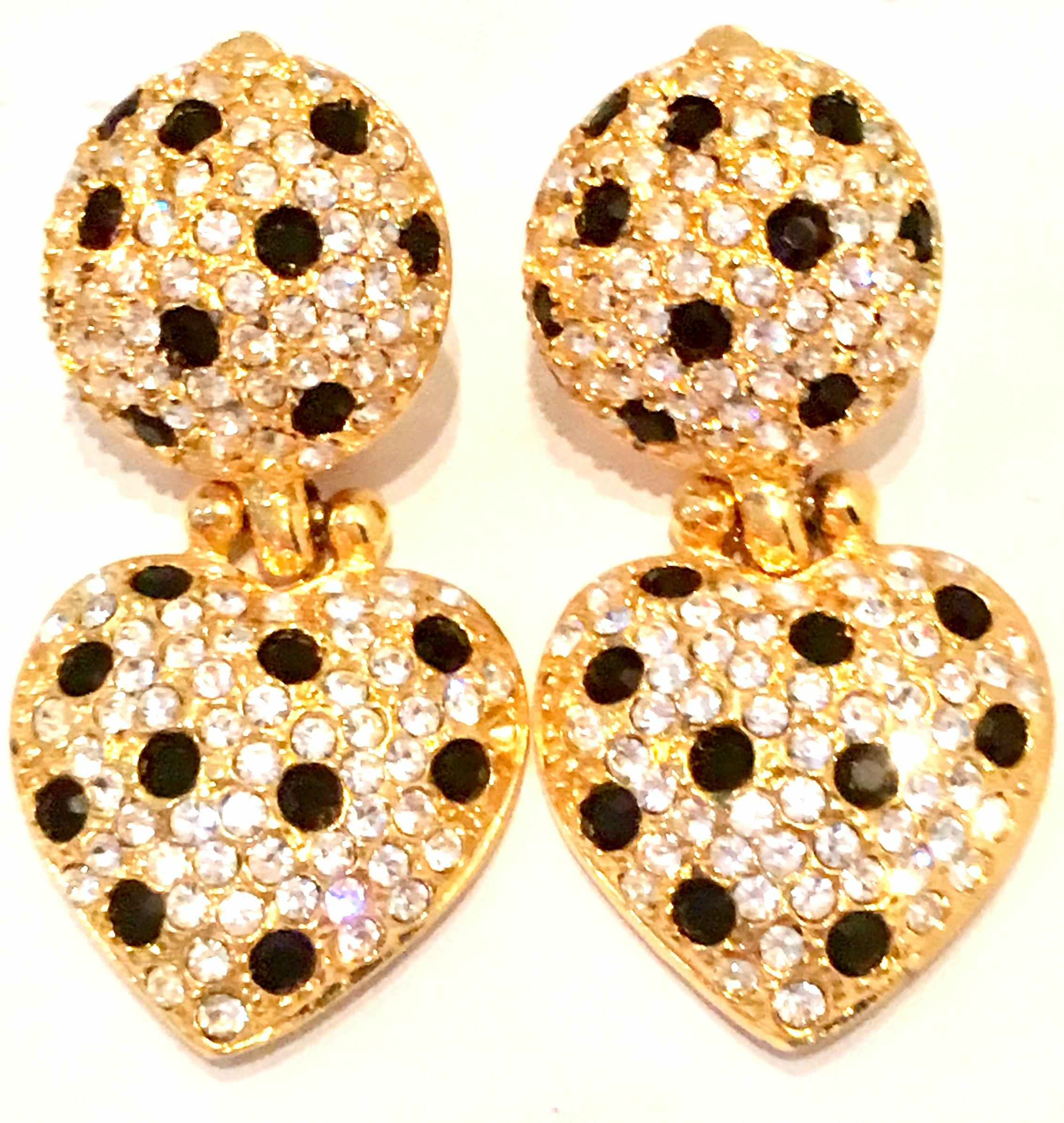 21st Century Gold Plate & Swarovski Crystal Heart Form Dangle Earrings By, Joan Rivers. These brilliant and sparking dangle earrings feature a round disc upper and heart form dangle ornament, encrusted with crystal clear and black cut and faceted
