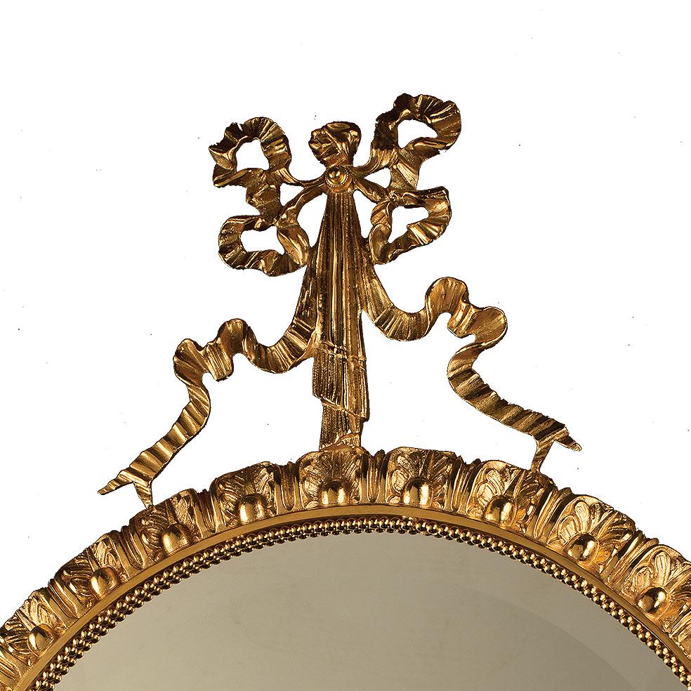 Miroir mural du 21e siècle avec cadre en bronze doré. La frise en forme d'arc sur le cadre du miroir est finement ciselée.  Sur demande, le client peut modifier la finition du métal : or français, bruni, bruni foncé, argent antique et or patiné afin