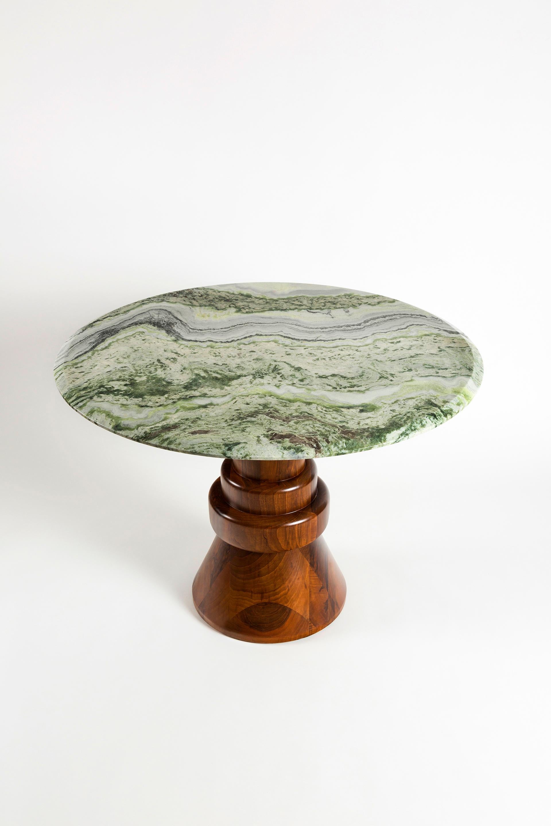 This playful handcrafted dining table is perfect to accommodate 4 people in smaller spaces. Green marble top is combined with sculptural wooden base and can be customized in different sizes and marble tops.