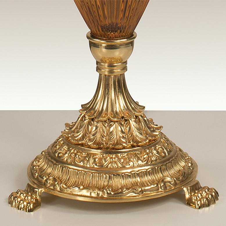 Lampe de table en cristal ambré taillé à la main et bronze en or patiné. Chaque objet est fabriqué à la main et le soin apporté à chaque détail rend chaque objet unique en son genre.
Le style de cette lampe de table est une réinterprétation moderne