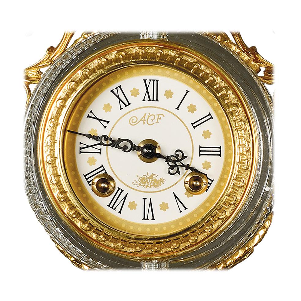 21st century hand carved clear crystal and golden bronze clock. This clock is finely chiseled lost wax castings and hand-grounded crystal. This clock has a mechanical 8 days wind movement and separate winding for alarm, chiming every half hour. On