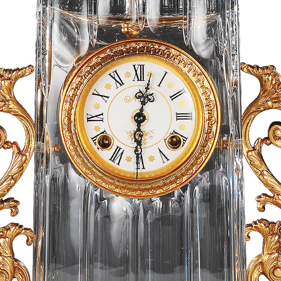 21st century Hand carved clear crystal and golden bronze clock. This clock is in hand-carved amber crystal and the dial is in white porcelain decorated in pure gold.  On request to customer can modificate the color of crystal: pink, amber amethist