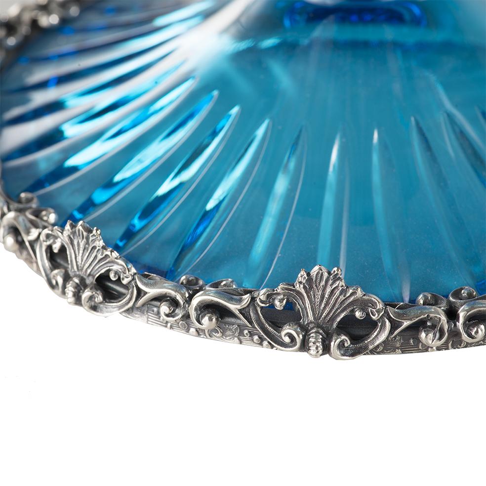 Coupe en cristal turquoise du 21e siècle, sculptée à la main, avec des parties métalliques en cire perdue en bronze argenté.
Ce centre de table est une édition limitée, nous n'avons que quelques pièces. Il est sculpté à la main et le soin apporté à