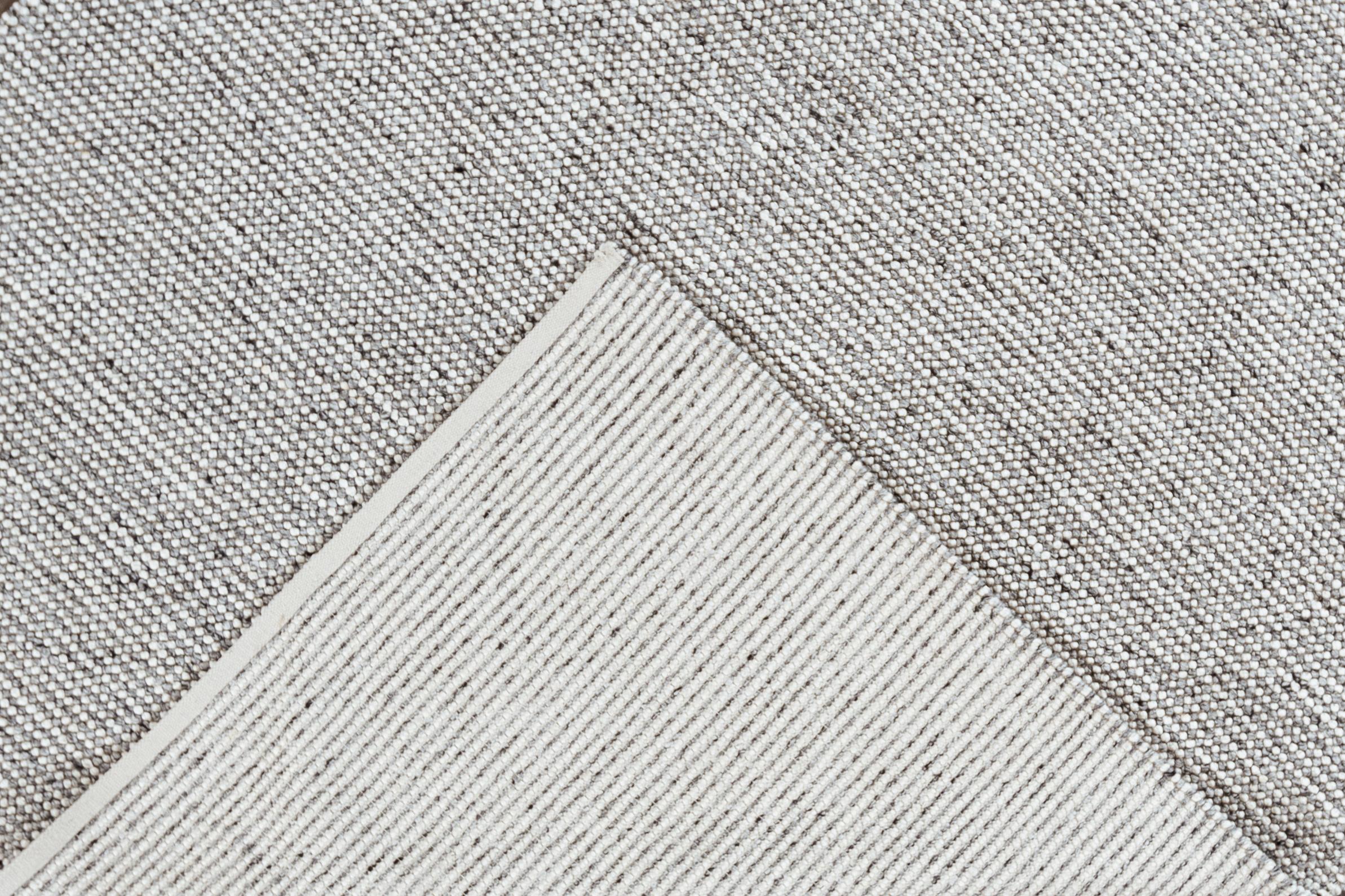 A 21st century modern handwoven textured wool rug with a solid gray motif. This rug measures at 8' x 10'2