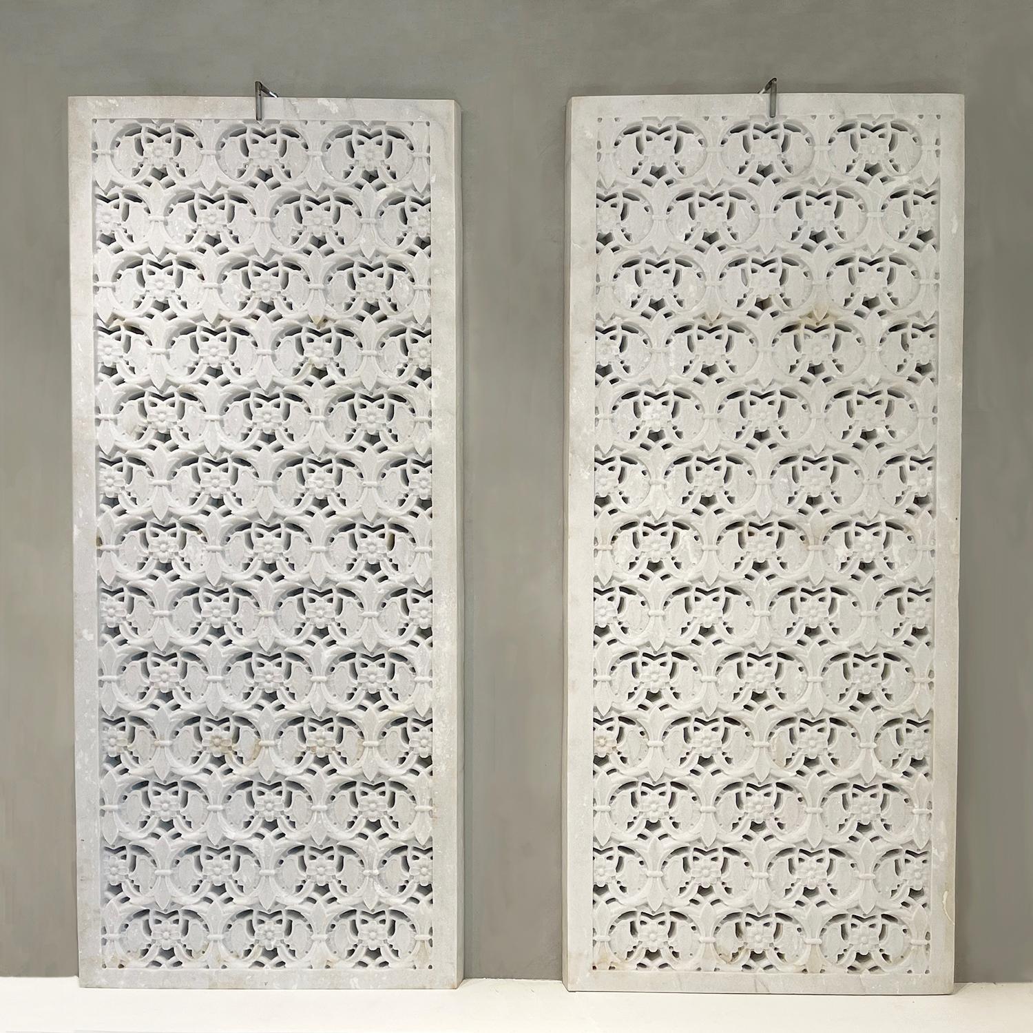 A set of hand carved white marble panels in a floral Jali with geometric flowers and design. This handcrafted architectural panel can be used as a table top, light diffuser, open air windows, privacy screen or sculptured object. Wear consistent with