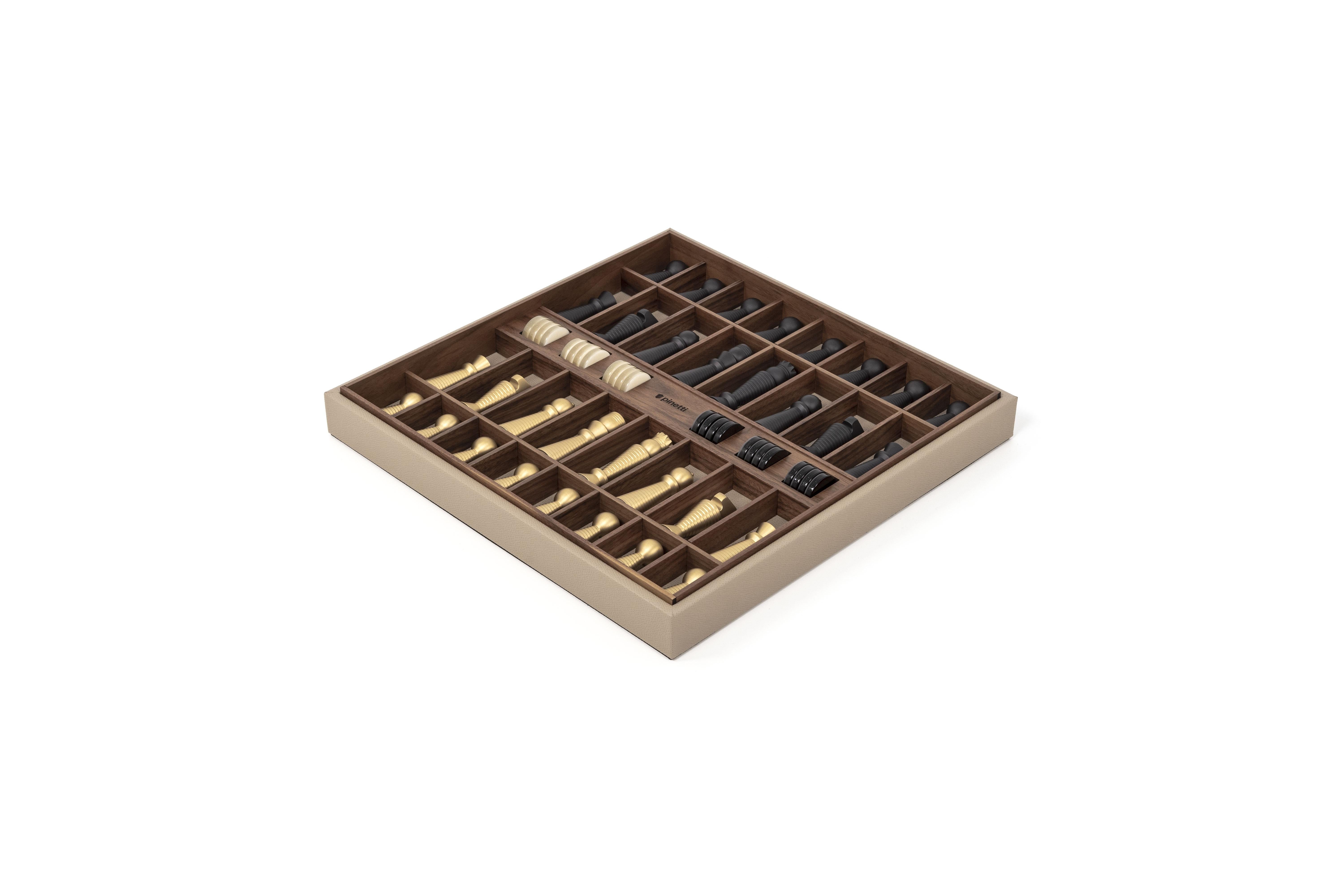 Two in one. A bicolour game board with an interior storage tray that houses the set’s pearled checkers and black and brass-finished chess pieces.

The class of a noble material such as walnut wood perfectly matches with the timeless beauty of