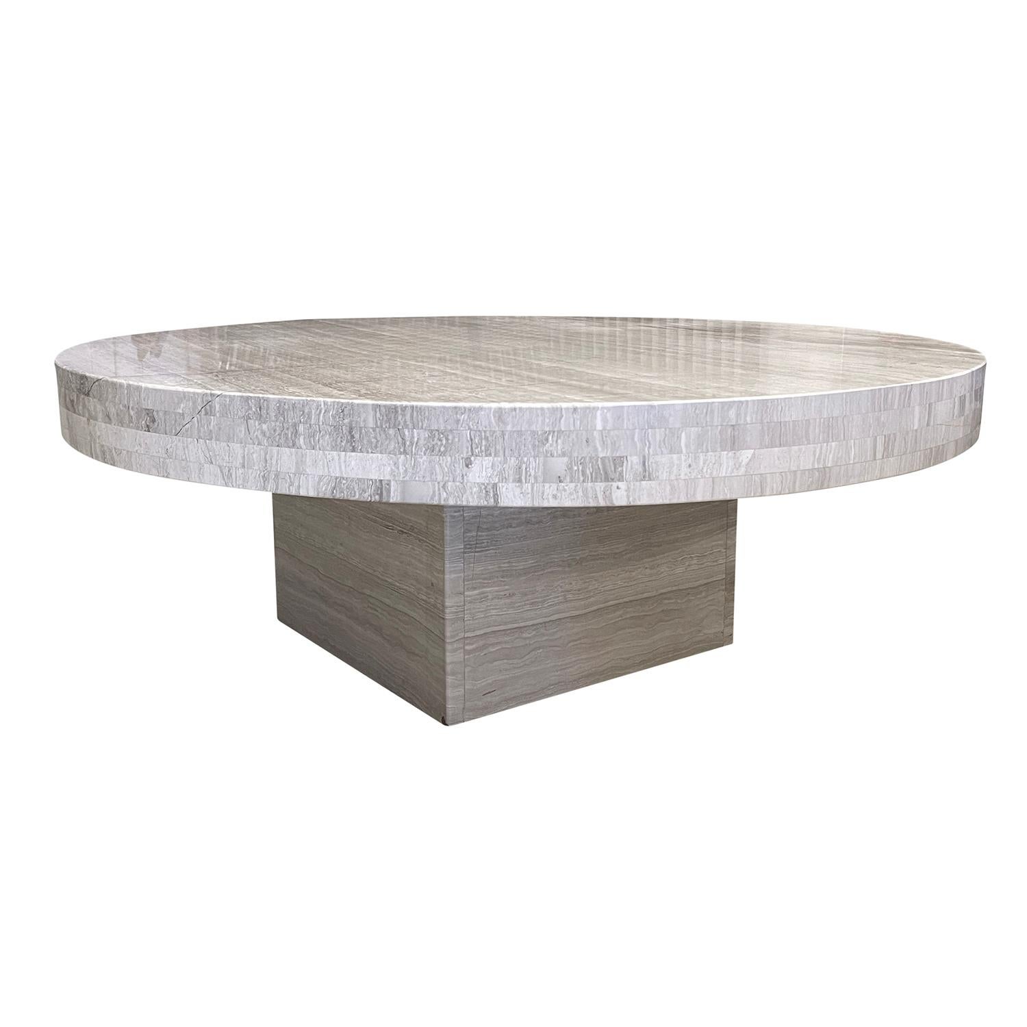 A round silver Italian coffee, side table made of hand crafted Travertine with a 3” thick top edging and a 0.75