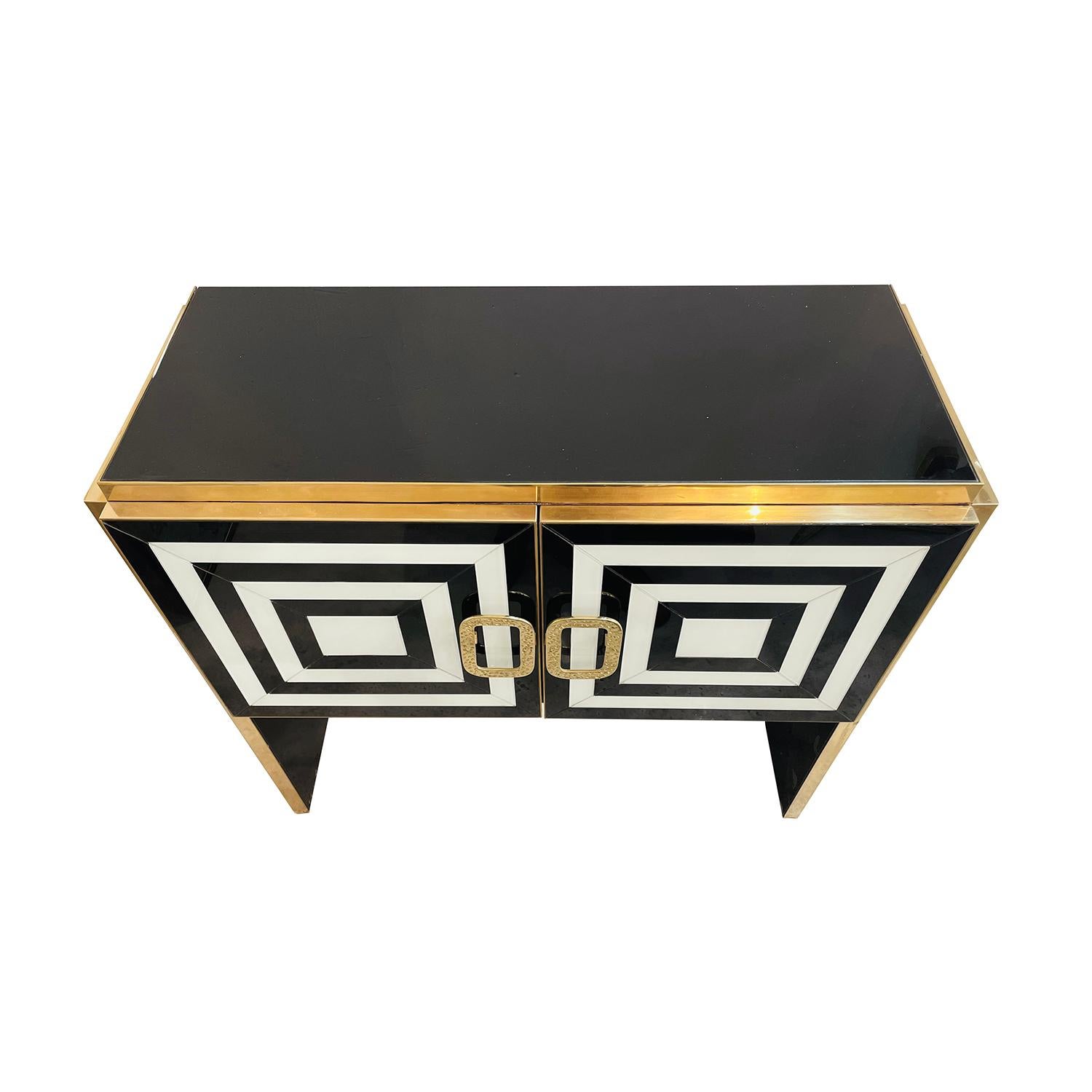 A black-white, Mid-Century modern style Italian illuminated sideboard made of hand blown colored Murano glass, in good condition. The interior of the two door cabinet is made of Walnut, particularized by many small mirrored glass pieces. The commode