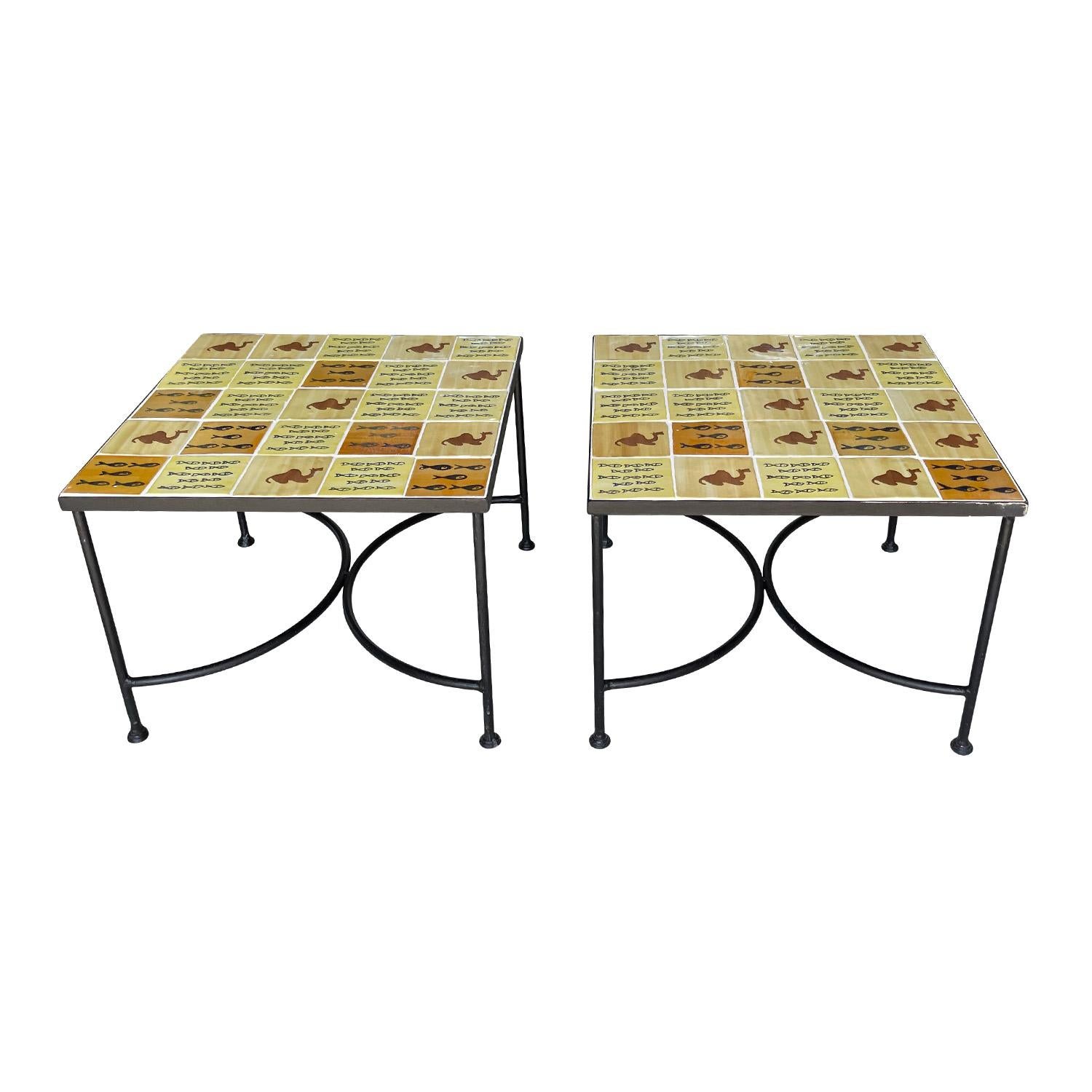 A pair of square Italian wrought iron side tables for the interior or exterior, in good condition. The vintage furniture has metal hammered bases combined with hand-painted vintage Tuscan tile table tops. The hand-painted animal tiles in different