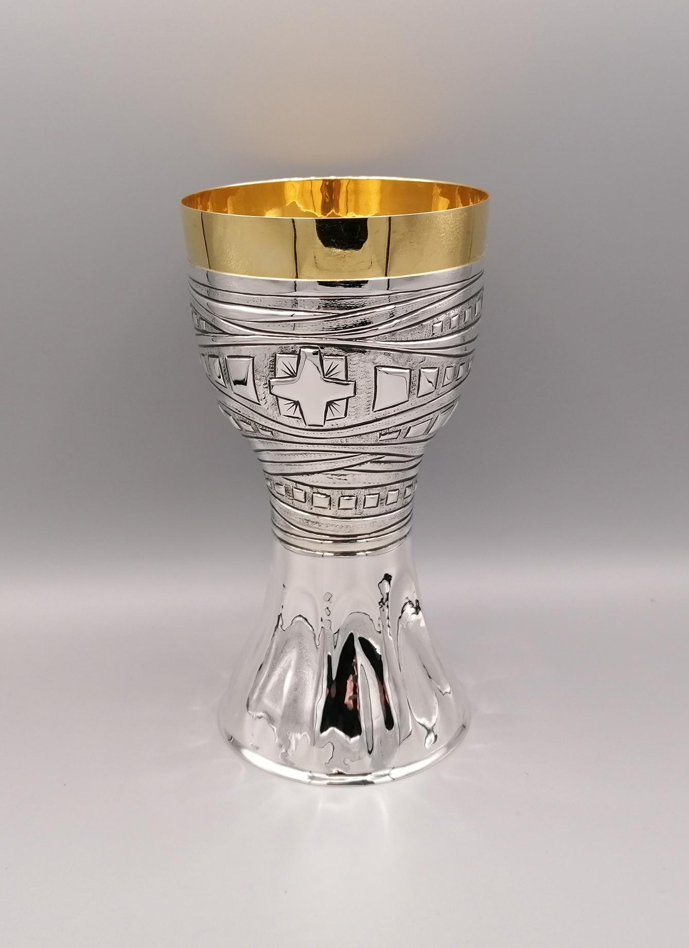 Solid sterling silver liturgical chalice, completely handmade.
The base is hammered and embossed with arched motifs that facilitate its grip. The middle part of the body is embossed and chiseled with a band design ending with equilateral
