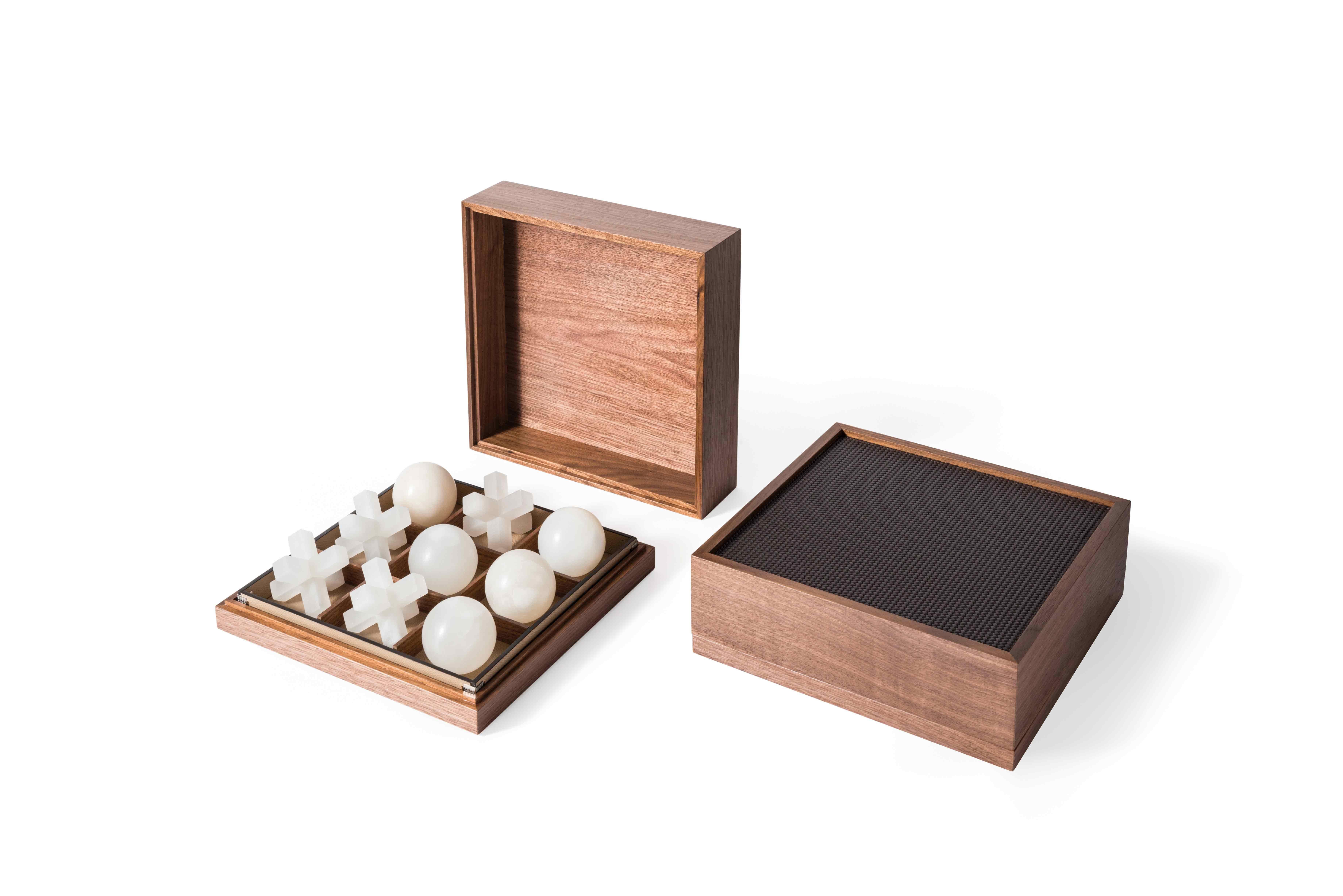 A masterpiece of style and design.

Pinetti Tic Tac Toe, our first addition to our board games collection. A canaletto walnut wood box covered with leather and completed with three-dimensional pieces made with the finest Volterra alabaster. A
